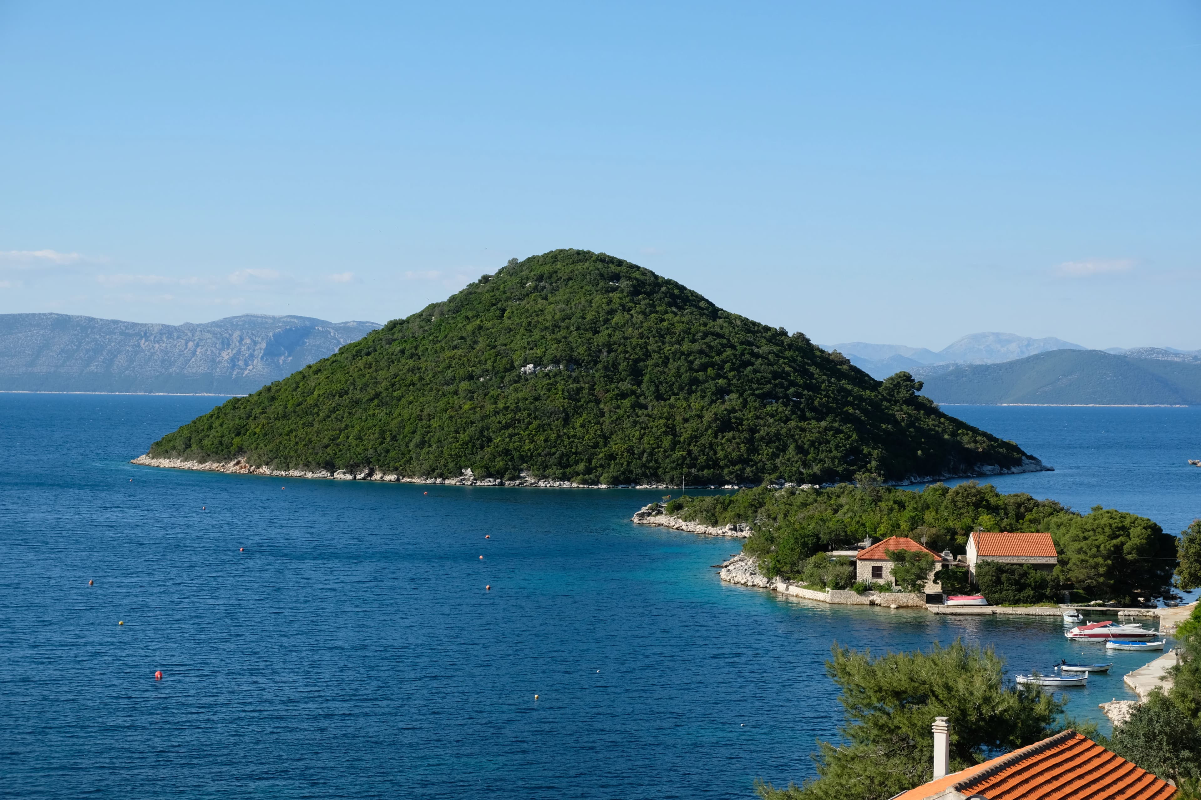 a body of water with a hill in the background