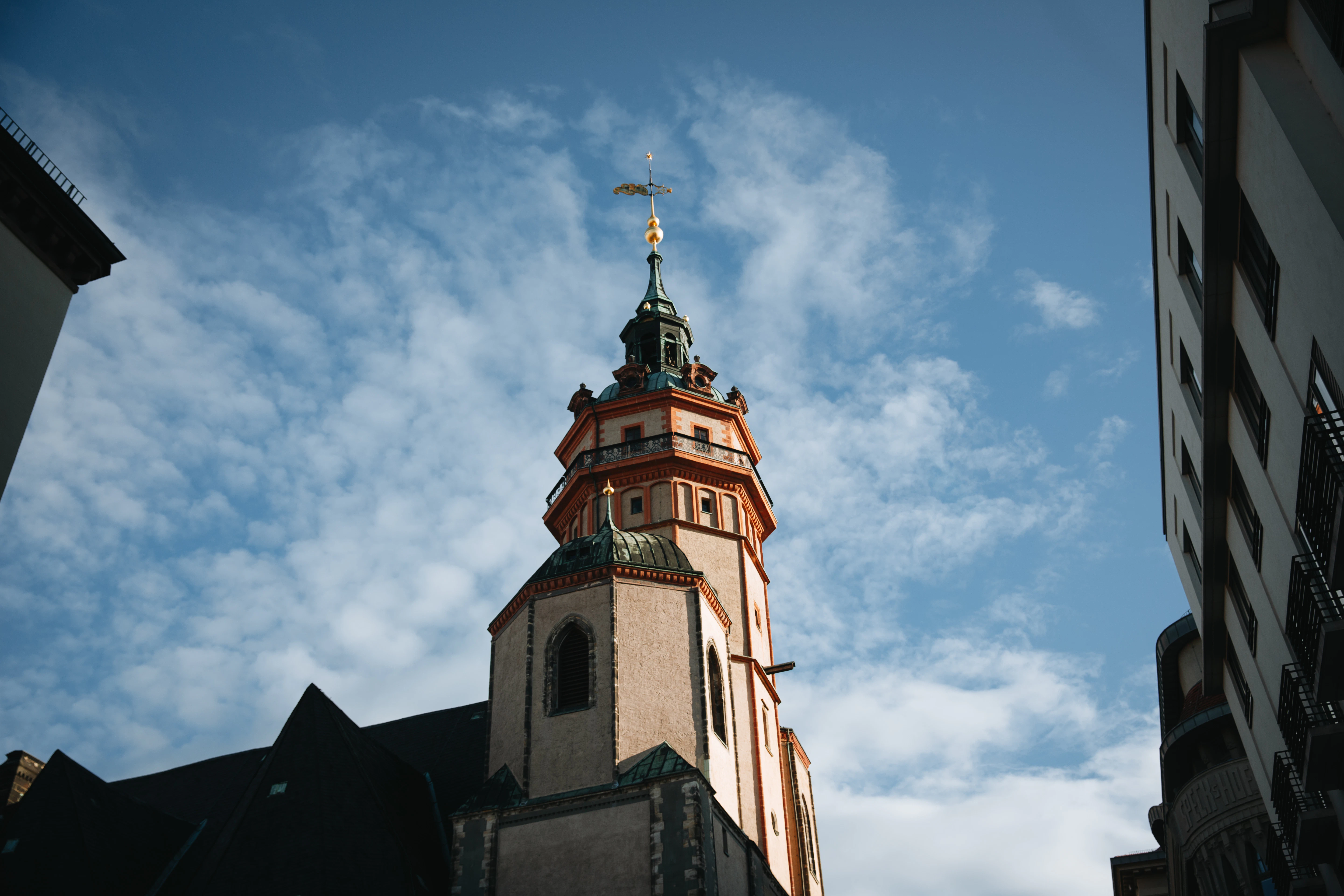 Tall church tower against a cloudy blue sky.