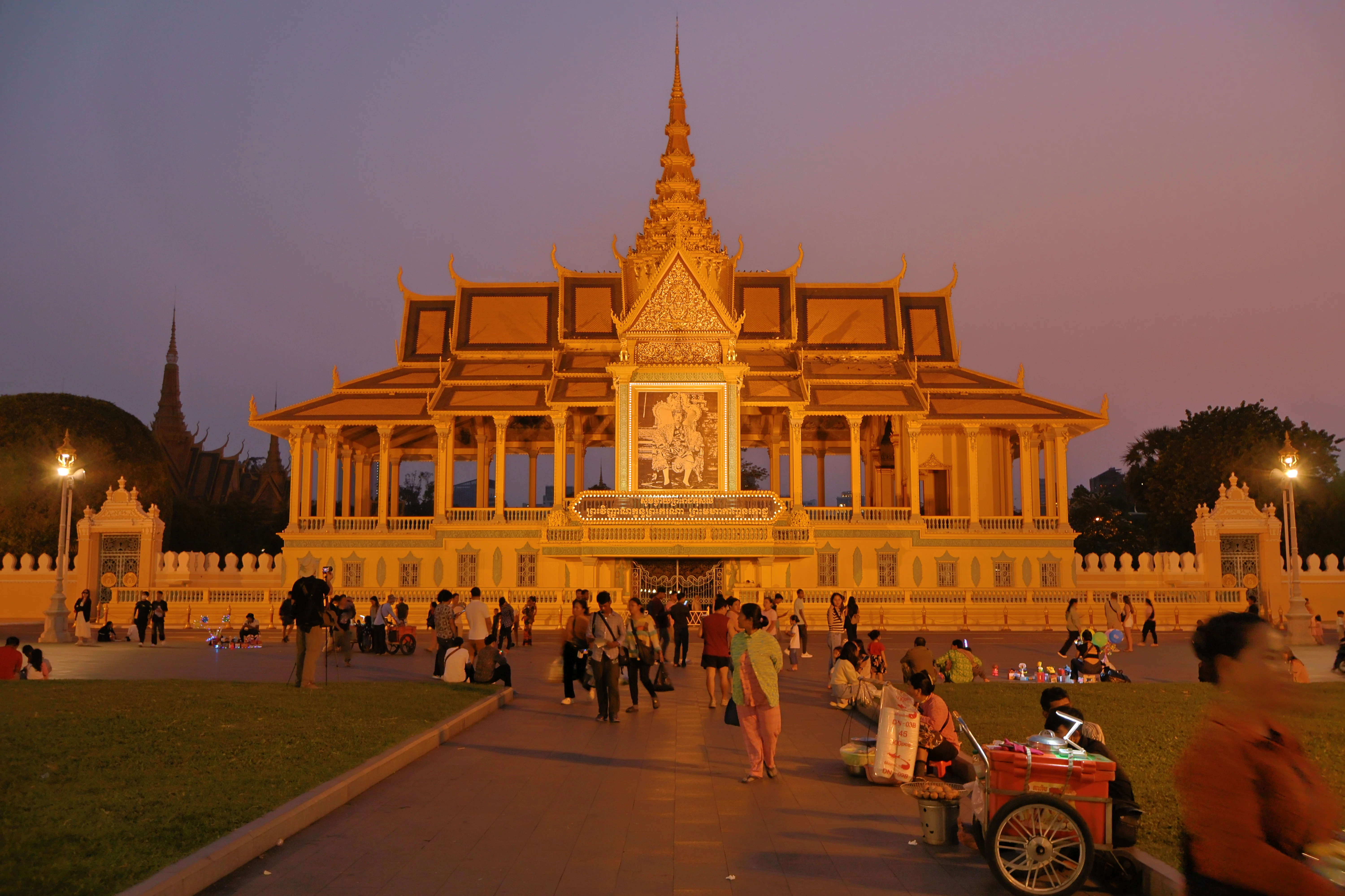 Royal palace building at dusk with people