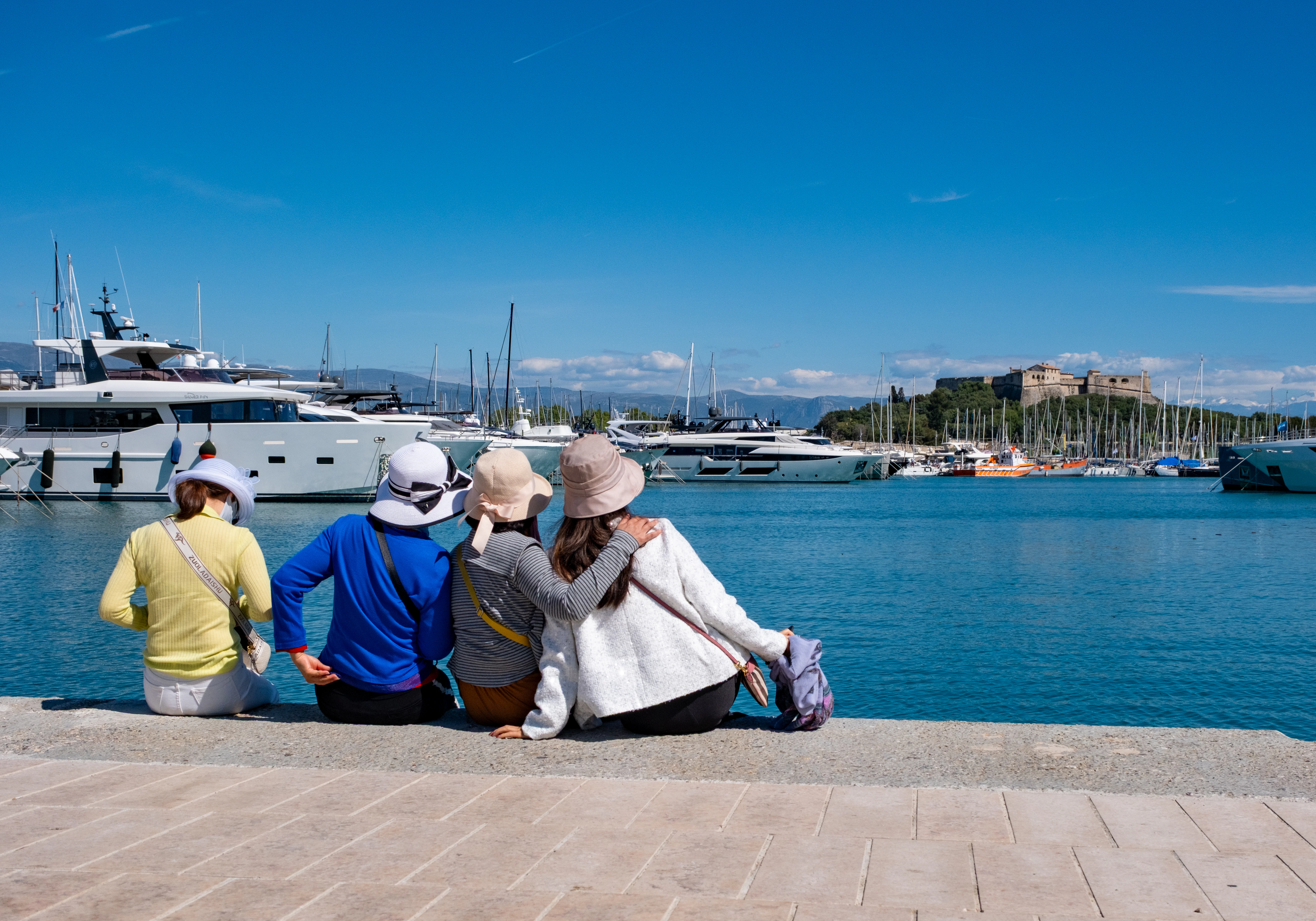Four people enjoy the seaside harbor view.