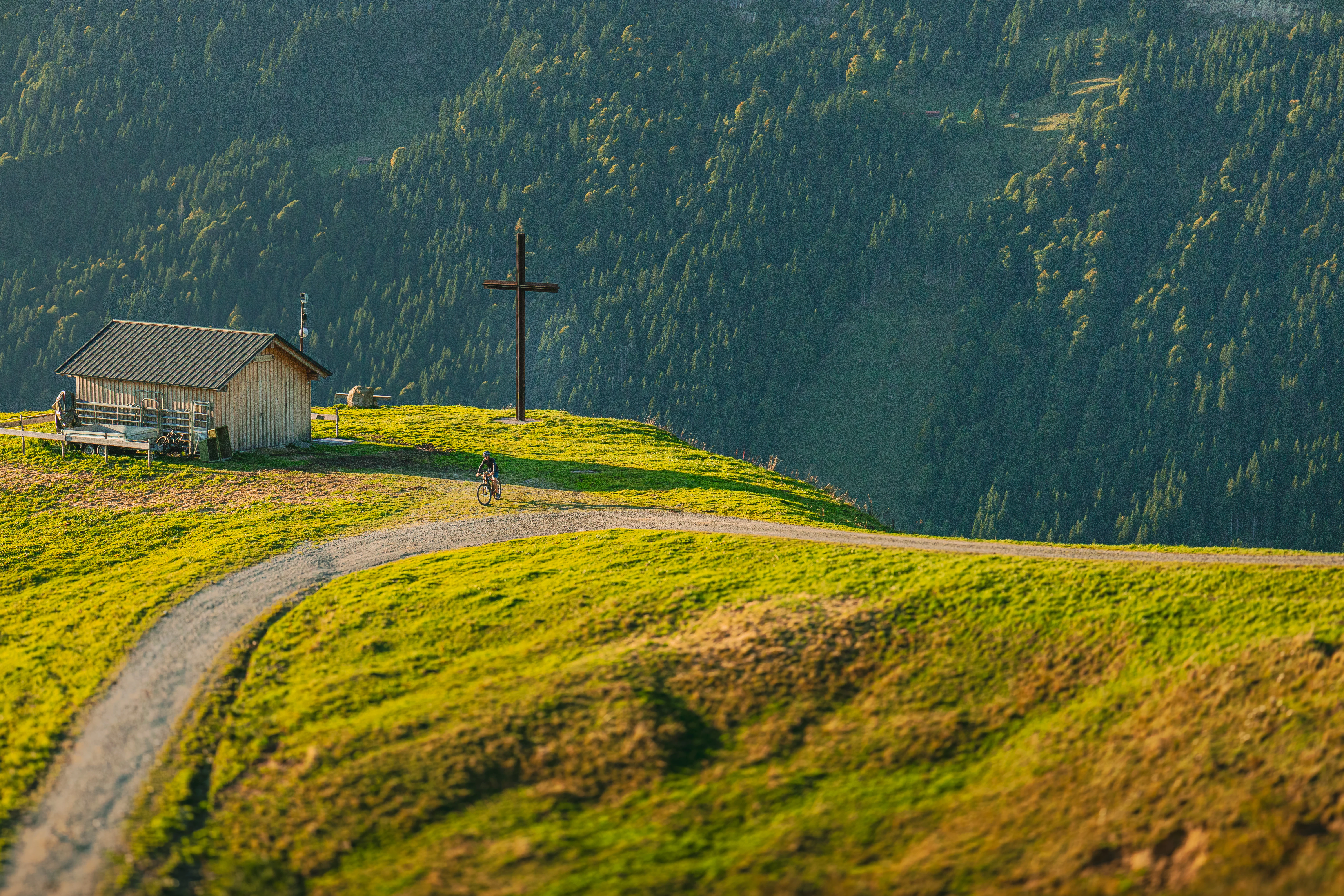 Small building on a grassy hillside with a winding path.