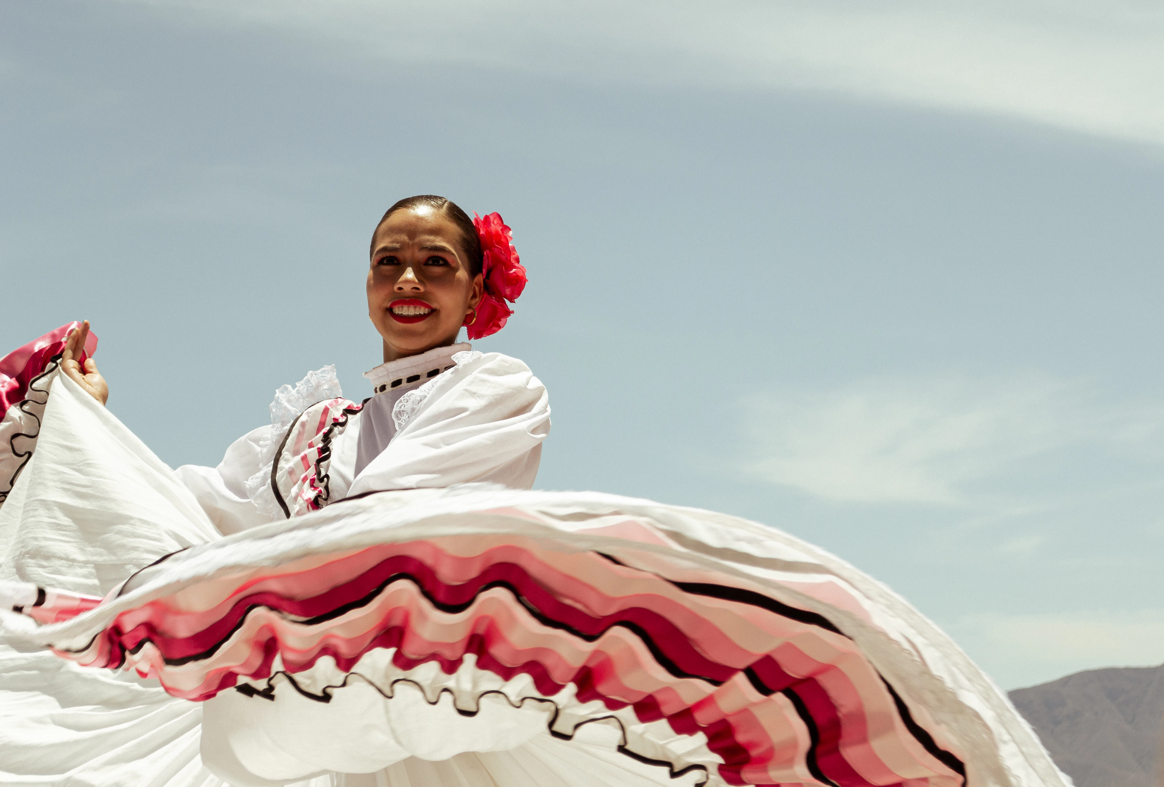 A woman in a white dress is riding a horse