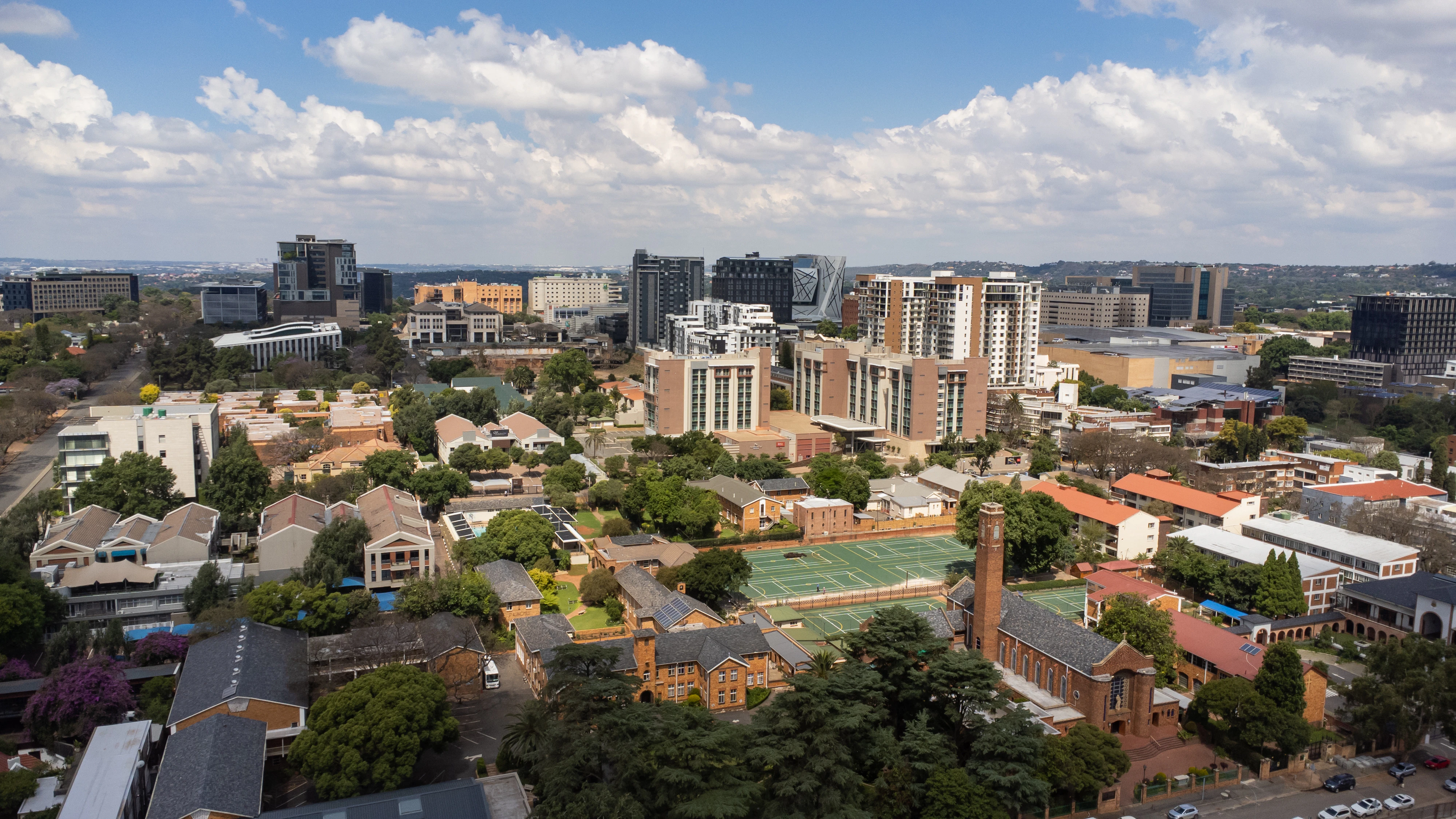 a view of a city with a tennis court in the foreground
