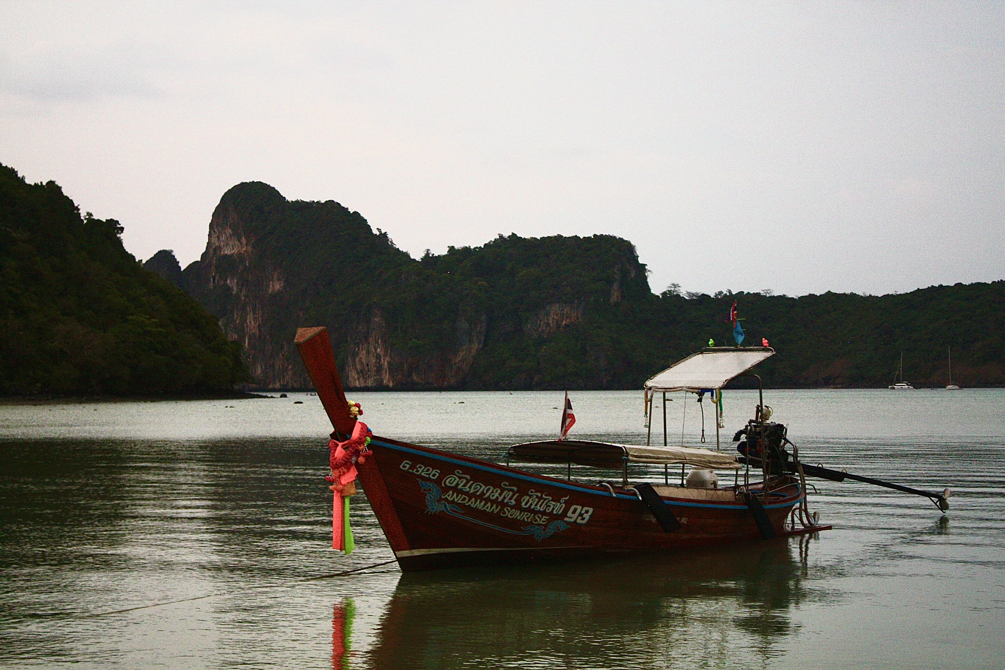 a long boat on a body of water with mountains in the background