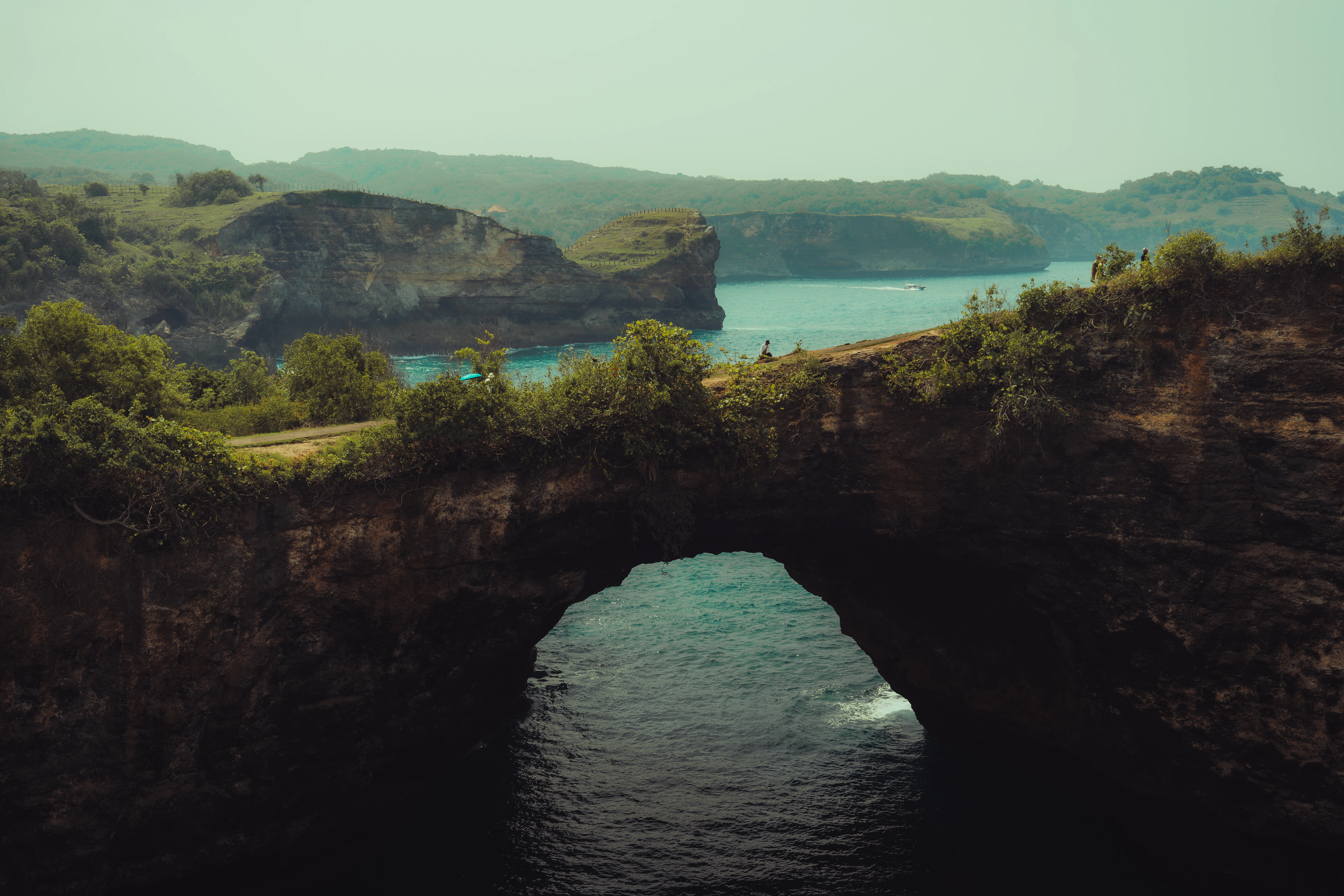 Ocean water flows through a natural stone arch.