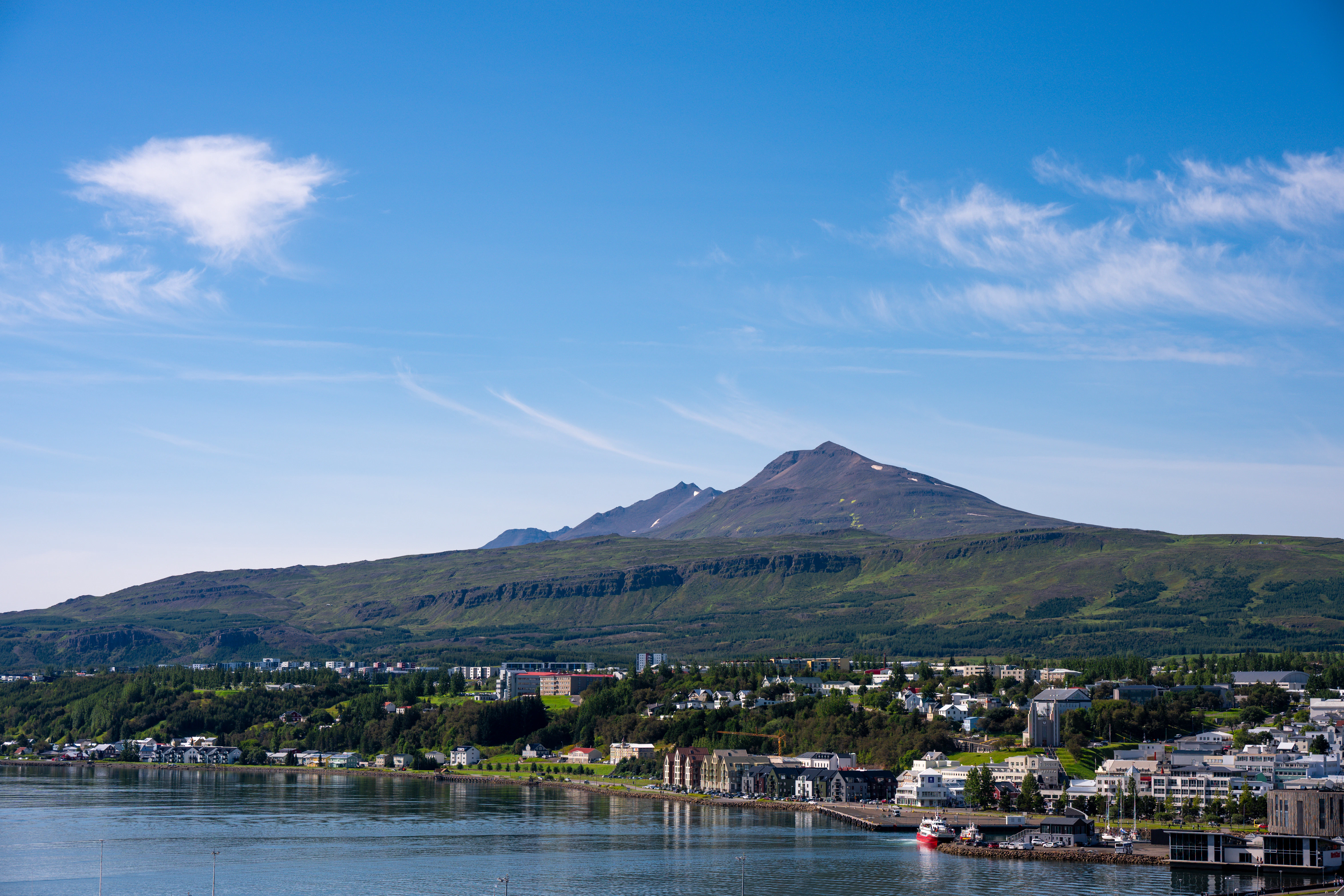 Coastal town with a mountain backdrop under a blue sky