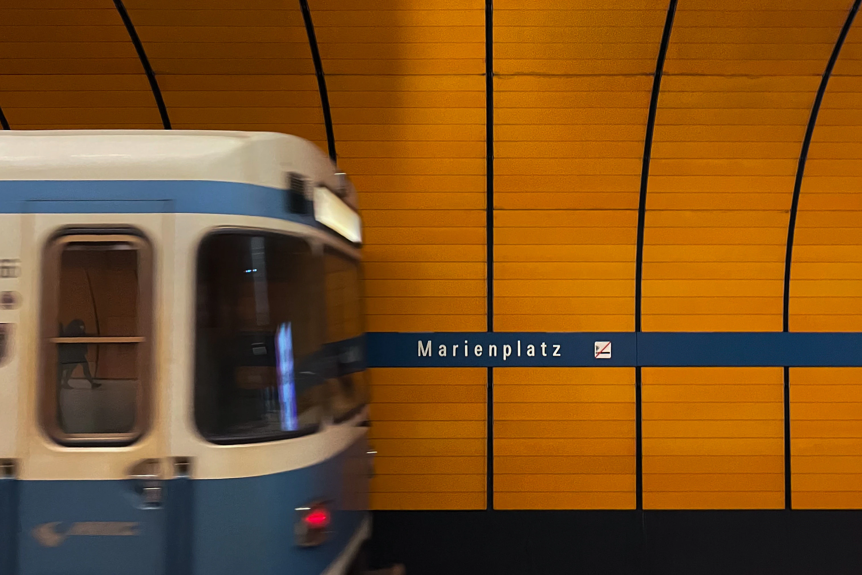 A blue and white train traveling through a tunnel