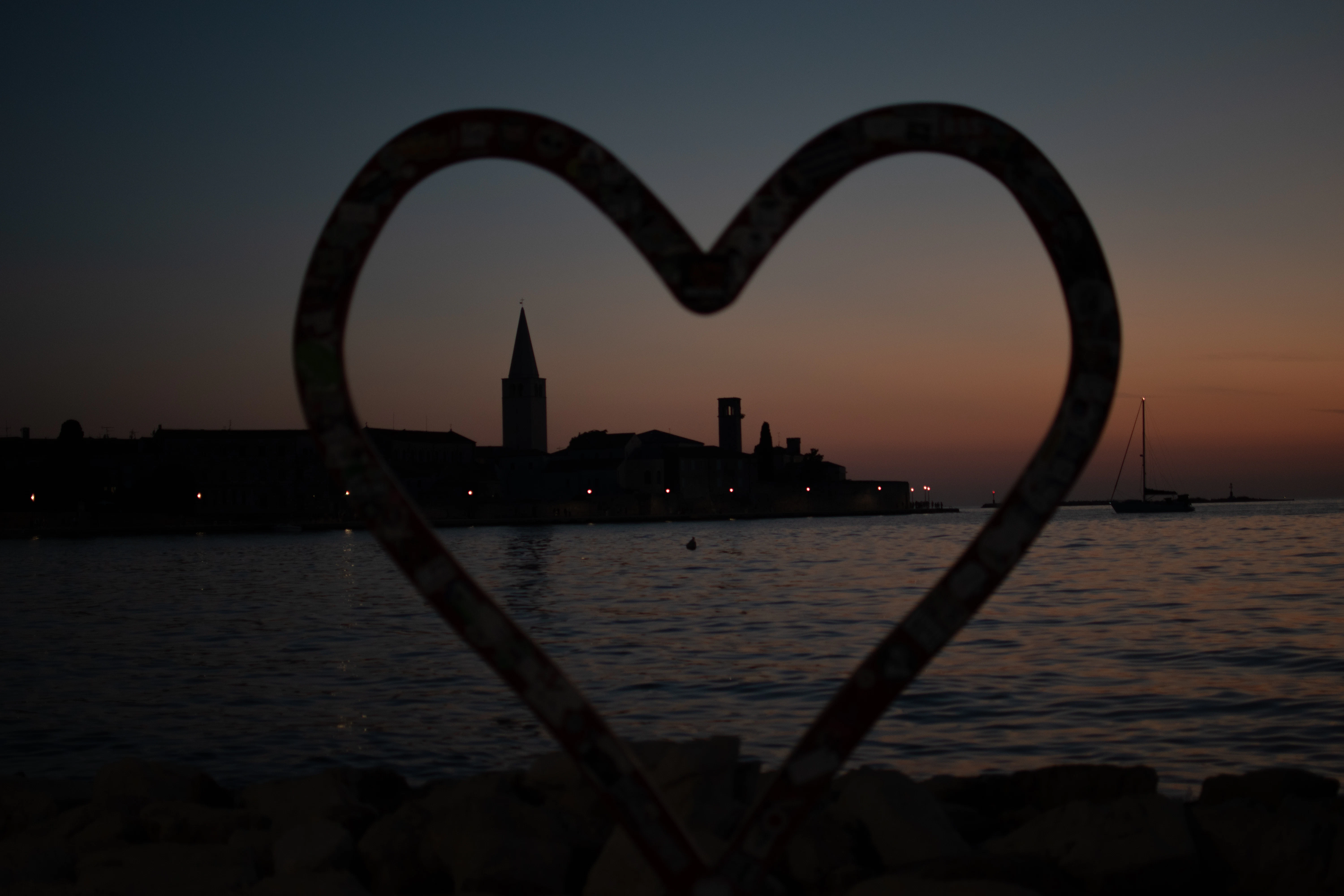 Heart frame overlooking coastal town at dusk