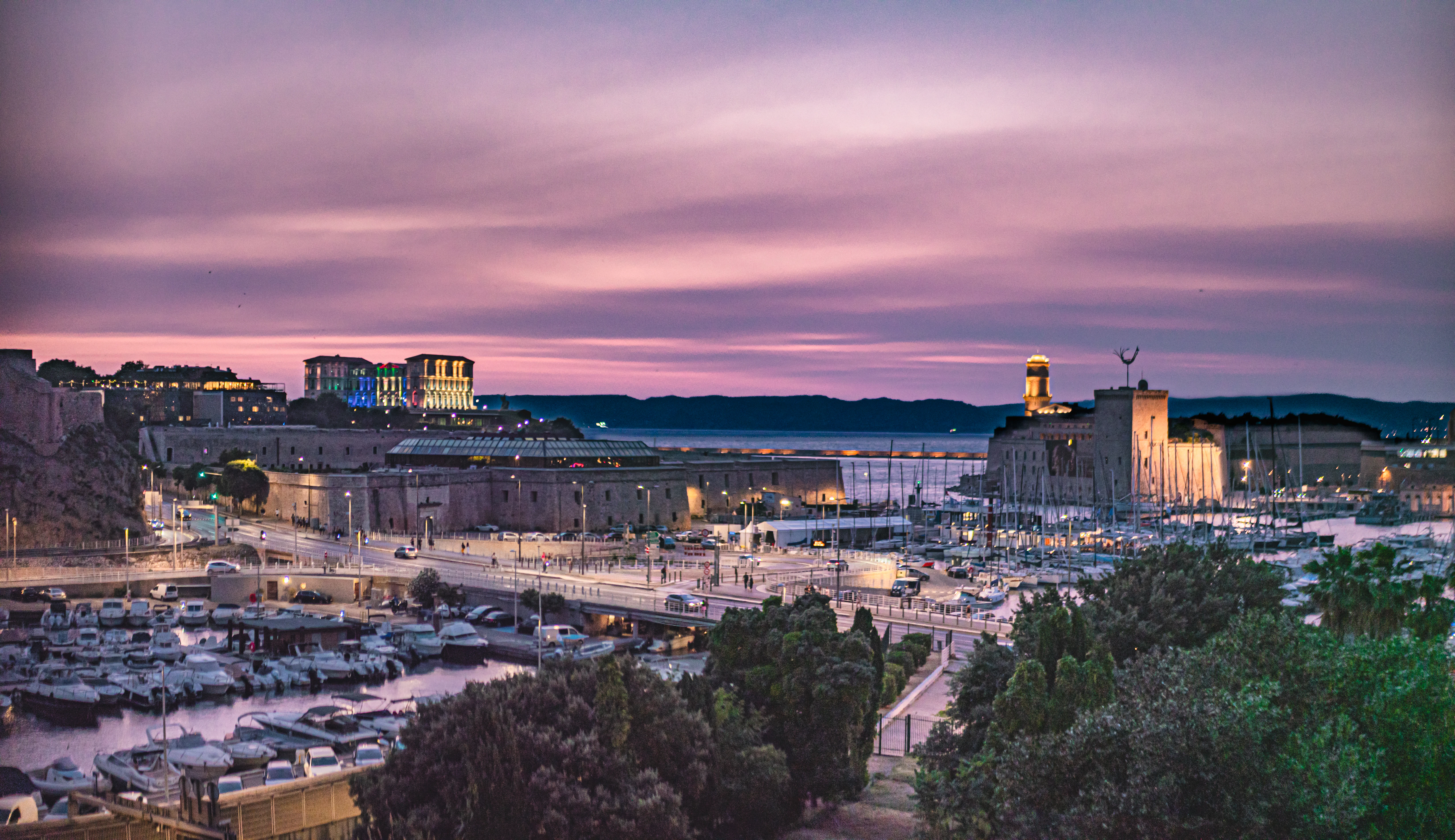 A harbor city is seen under a dusky sky.