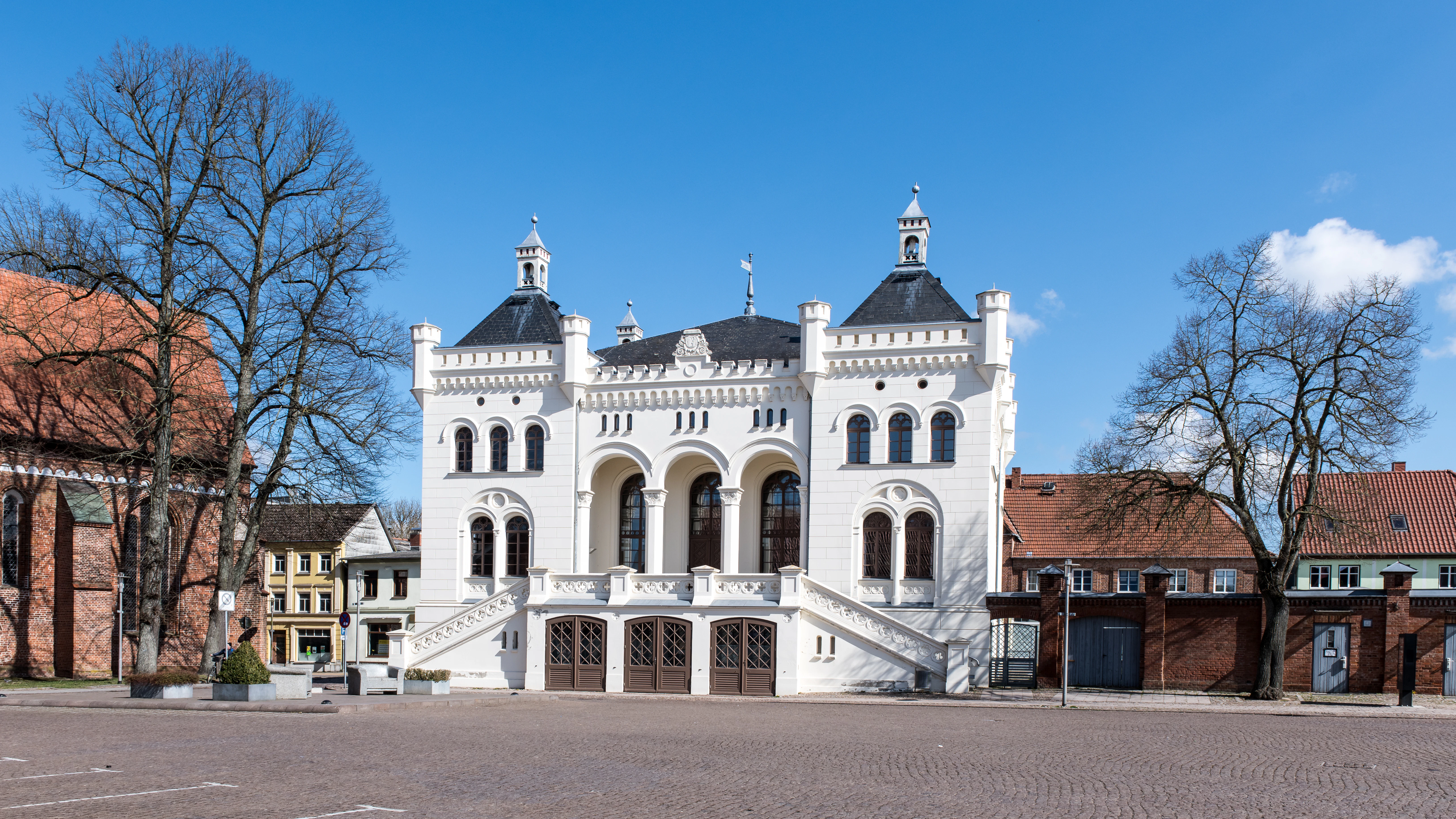 White ornate building with arched windows and towers.