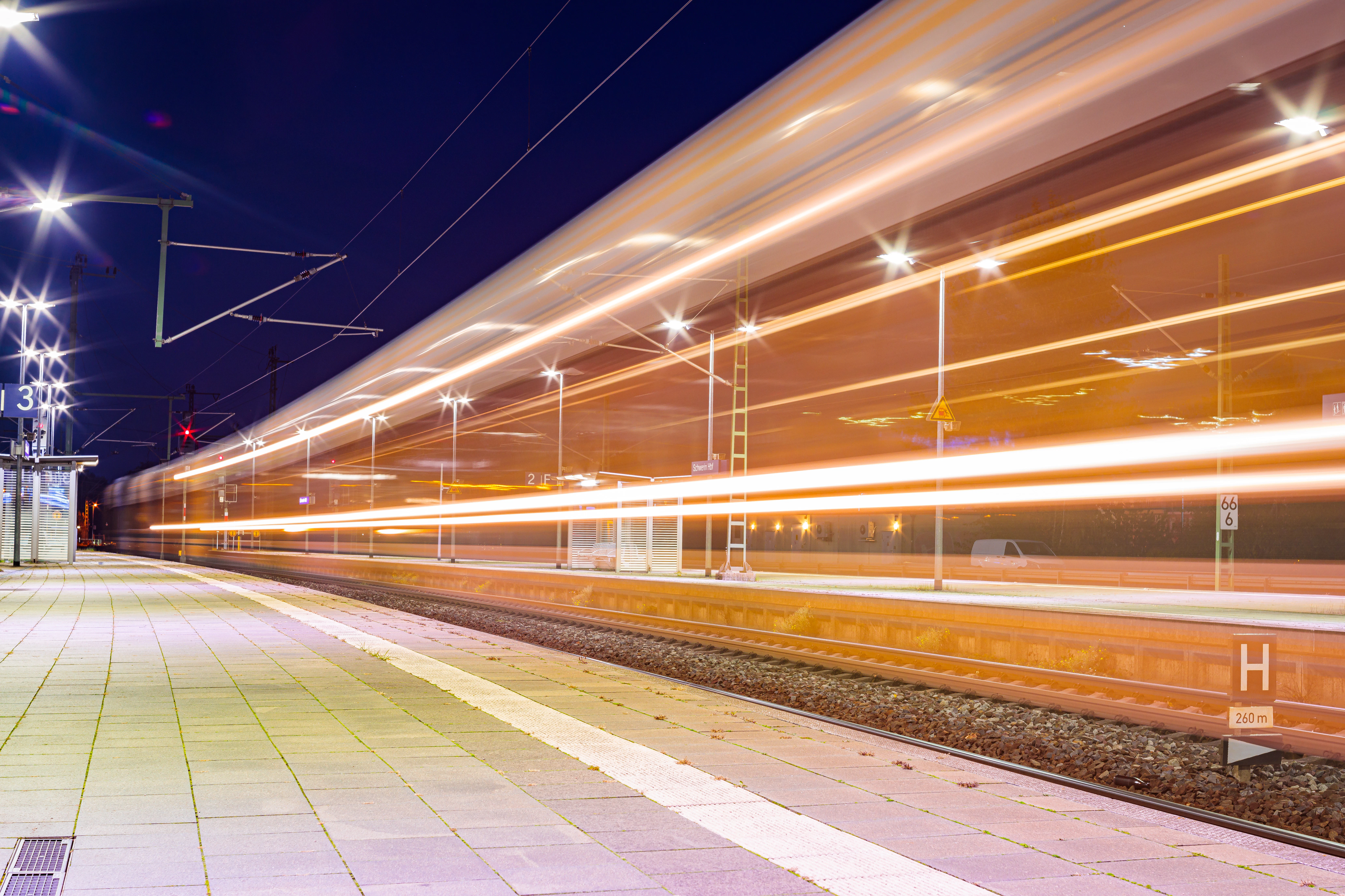 A train traveling down train tracks next to a train station