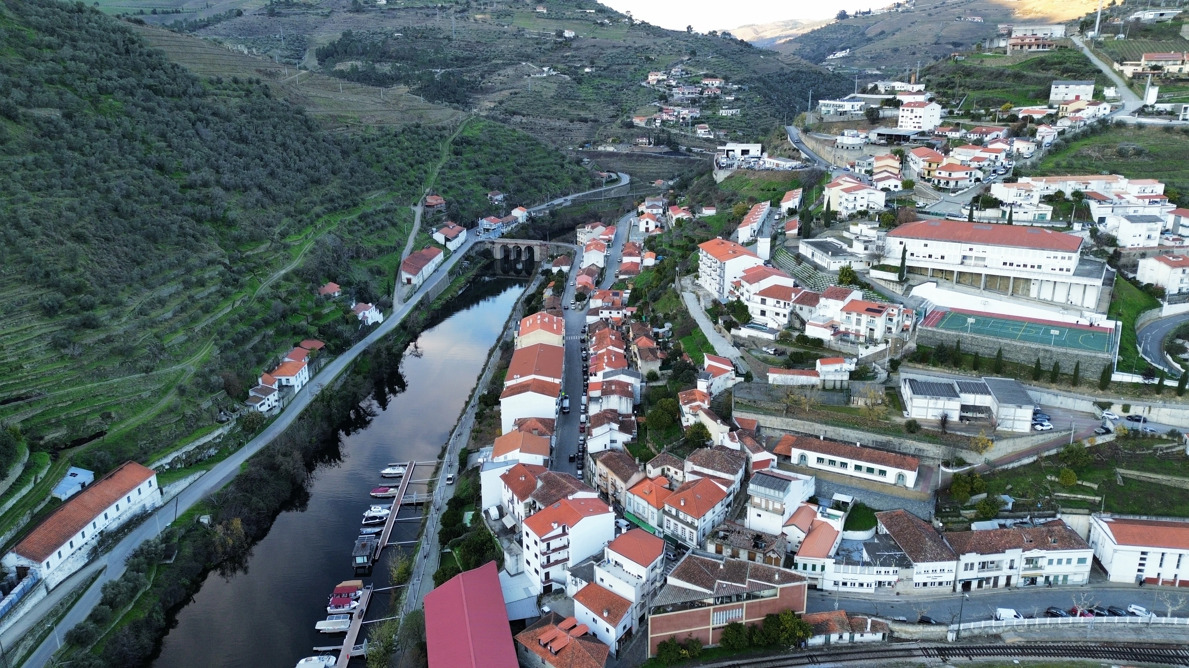 River flowing through a town nestled in green hills.