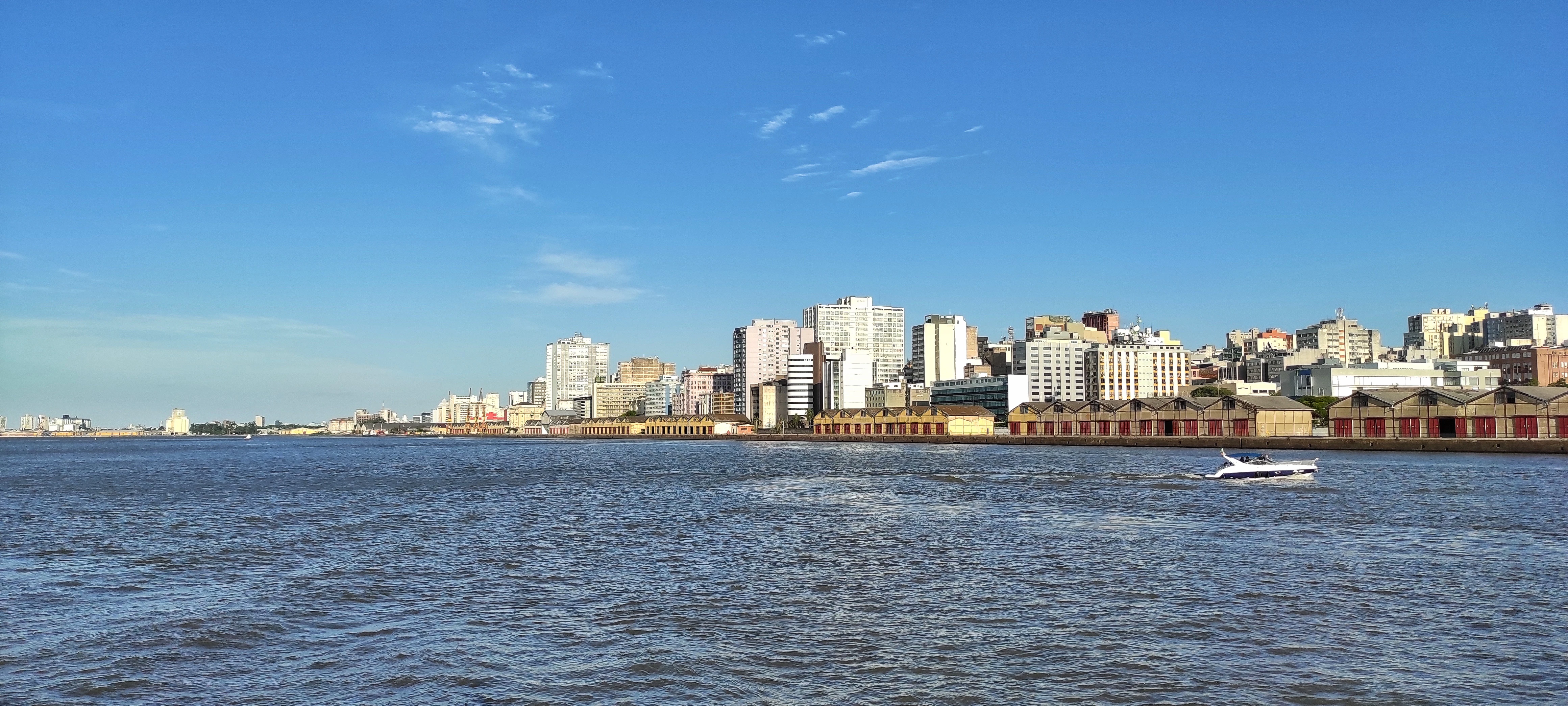 a boat traveling down a river next to a city