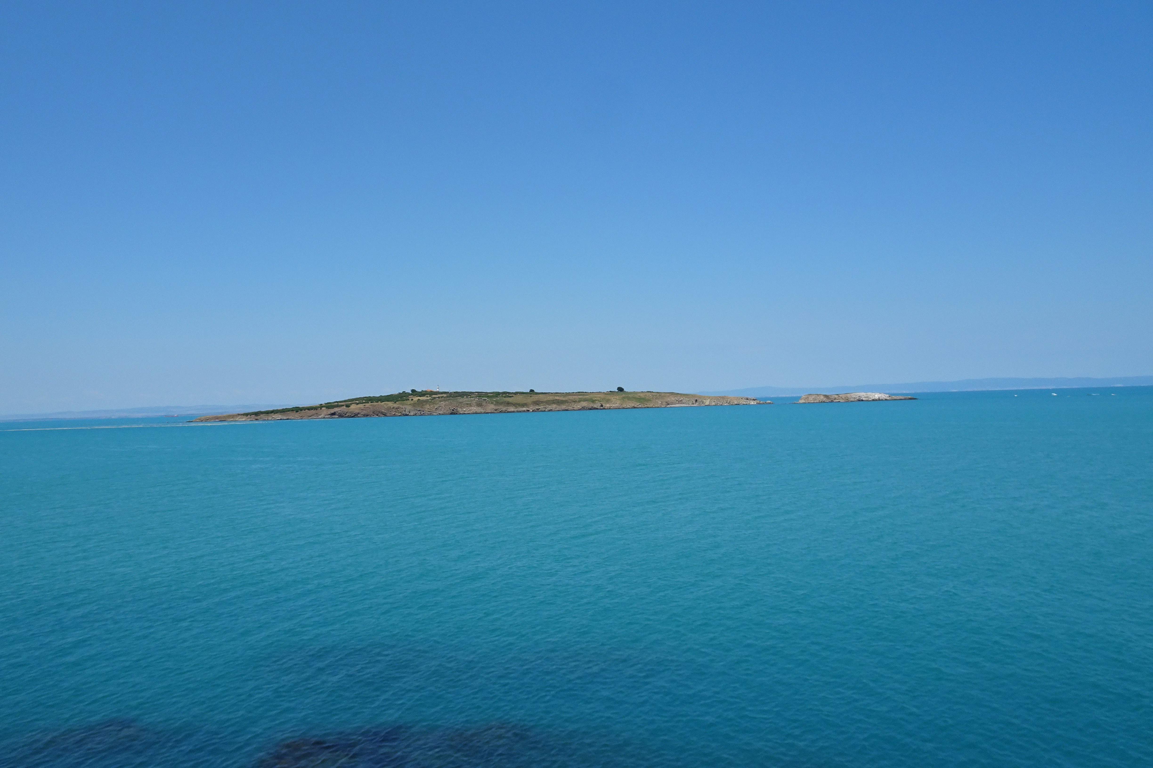 a large body of water with a small island in the distance