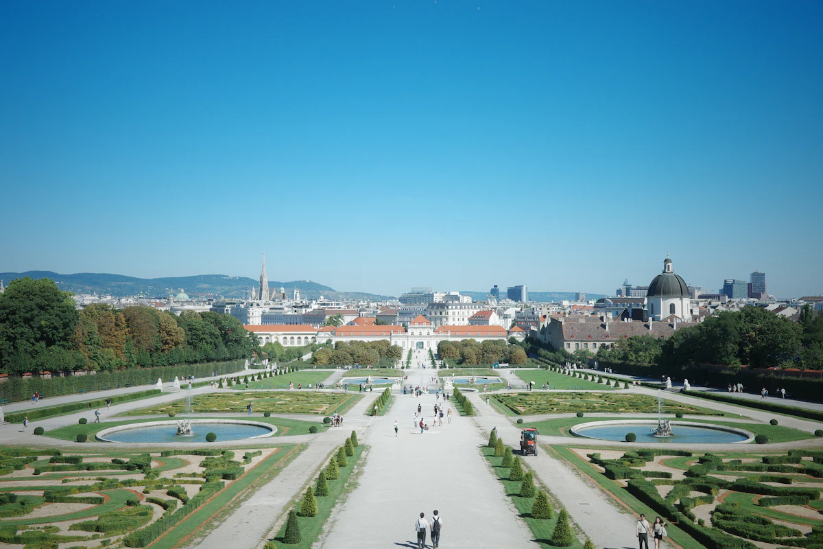 Formal gardens and city skyline under a clear blue sky