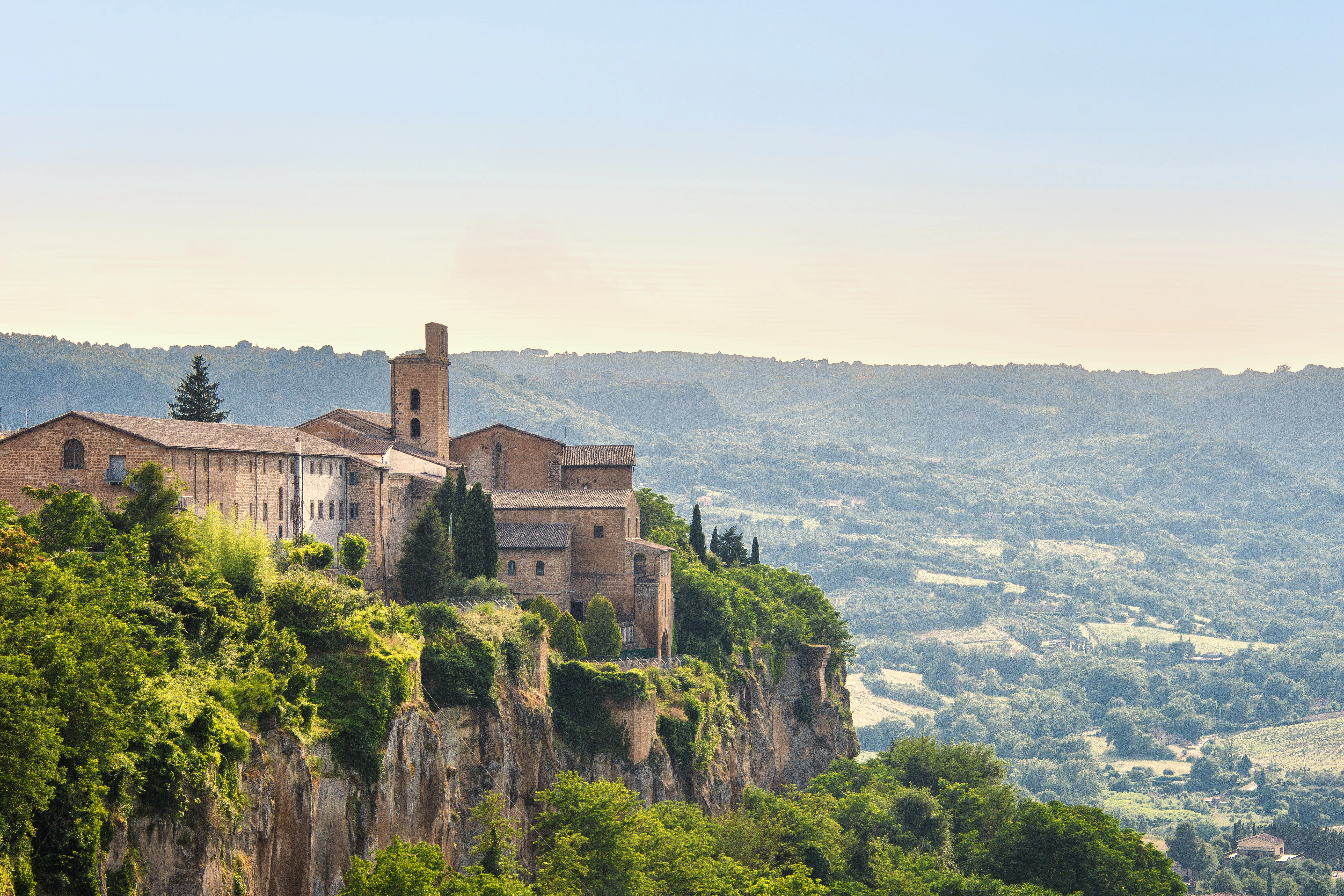a small village on a cliff surrounded by trees