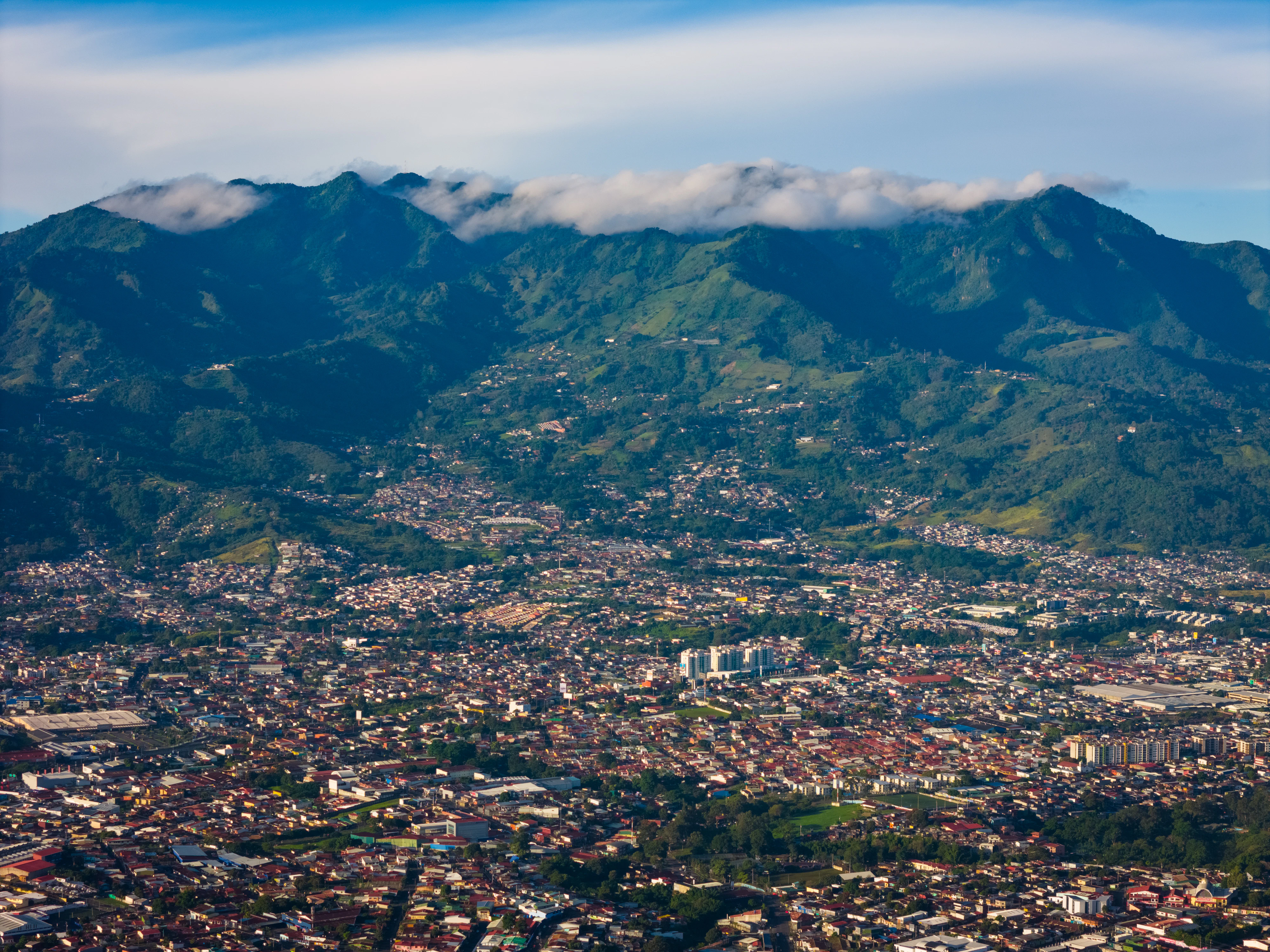 an aerial view of a city with mountains in the background