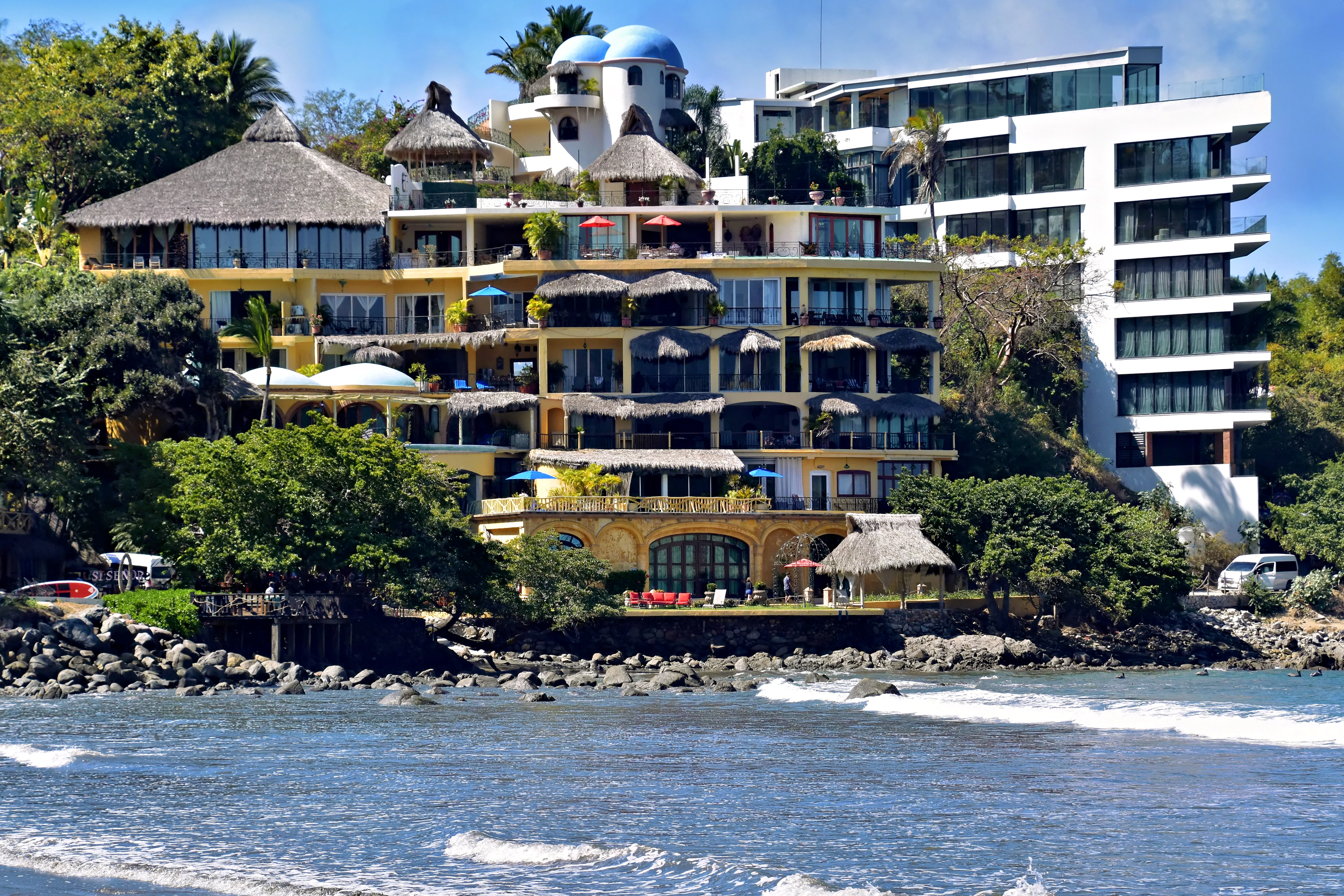 Luxury beachfront resort with blue domes and balconies.