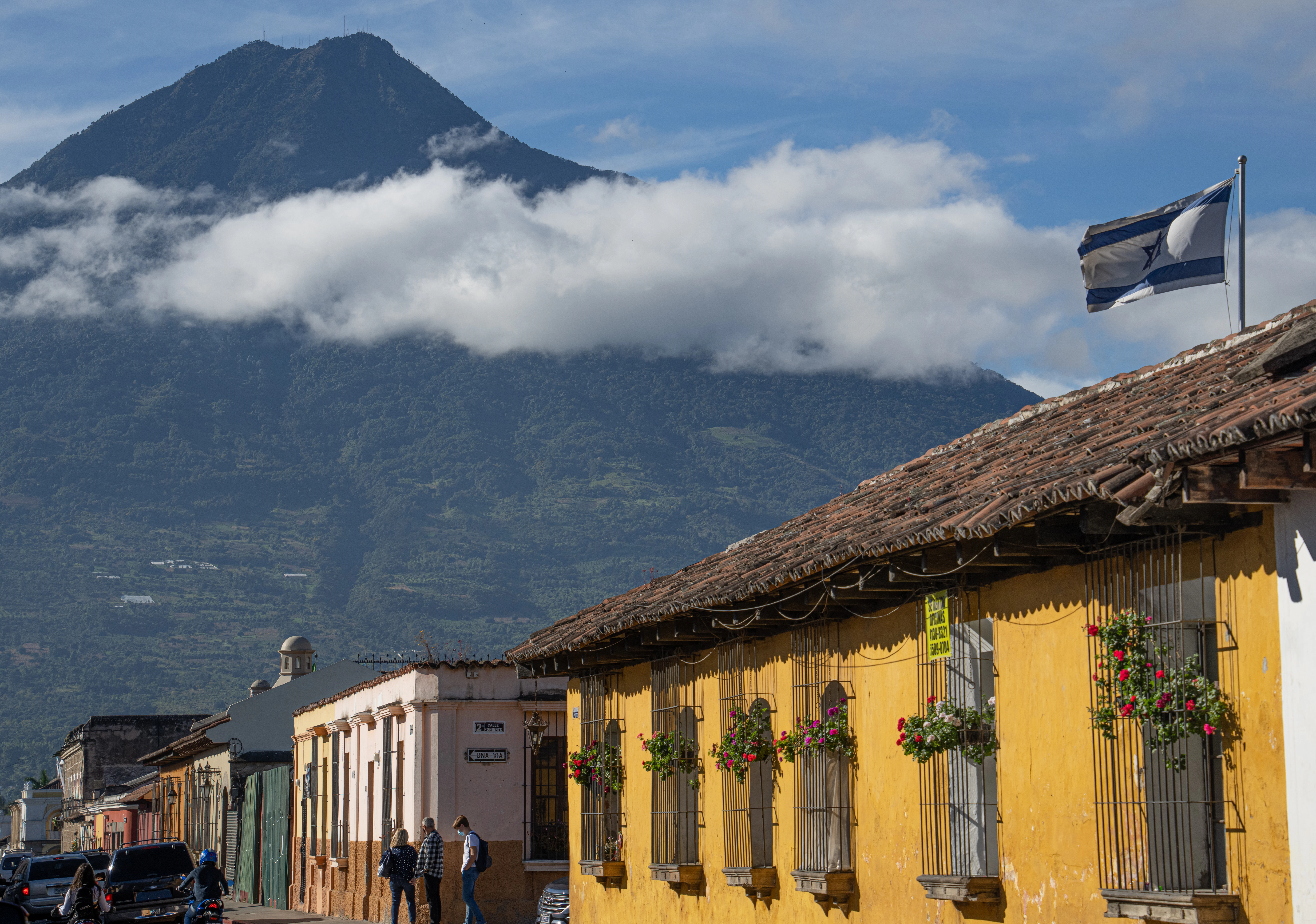 a yellow building with a mountain in the background
