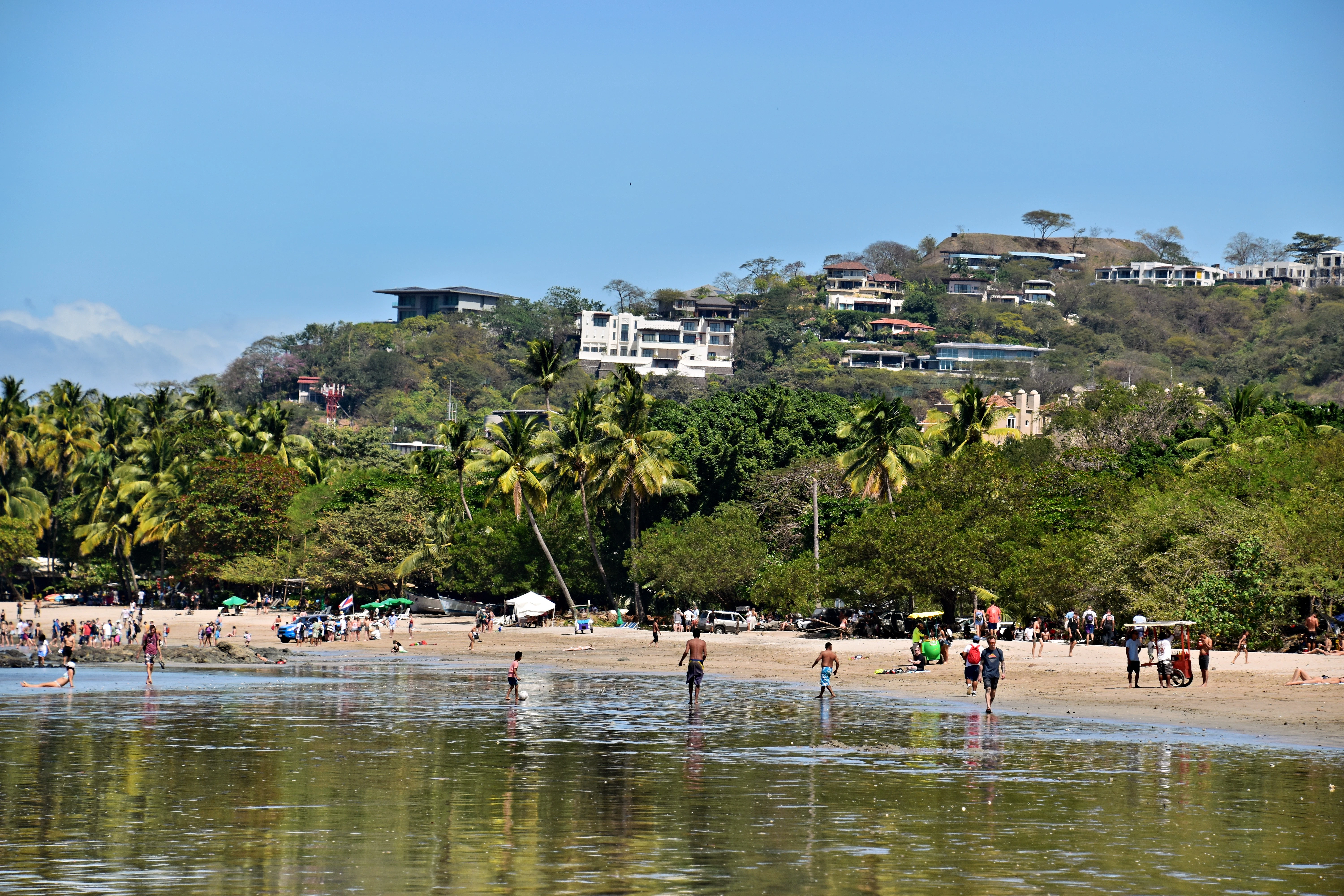 a group of people standing on top of a sandy beach