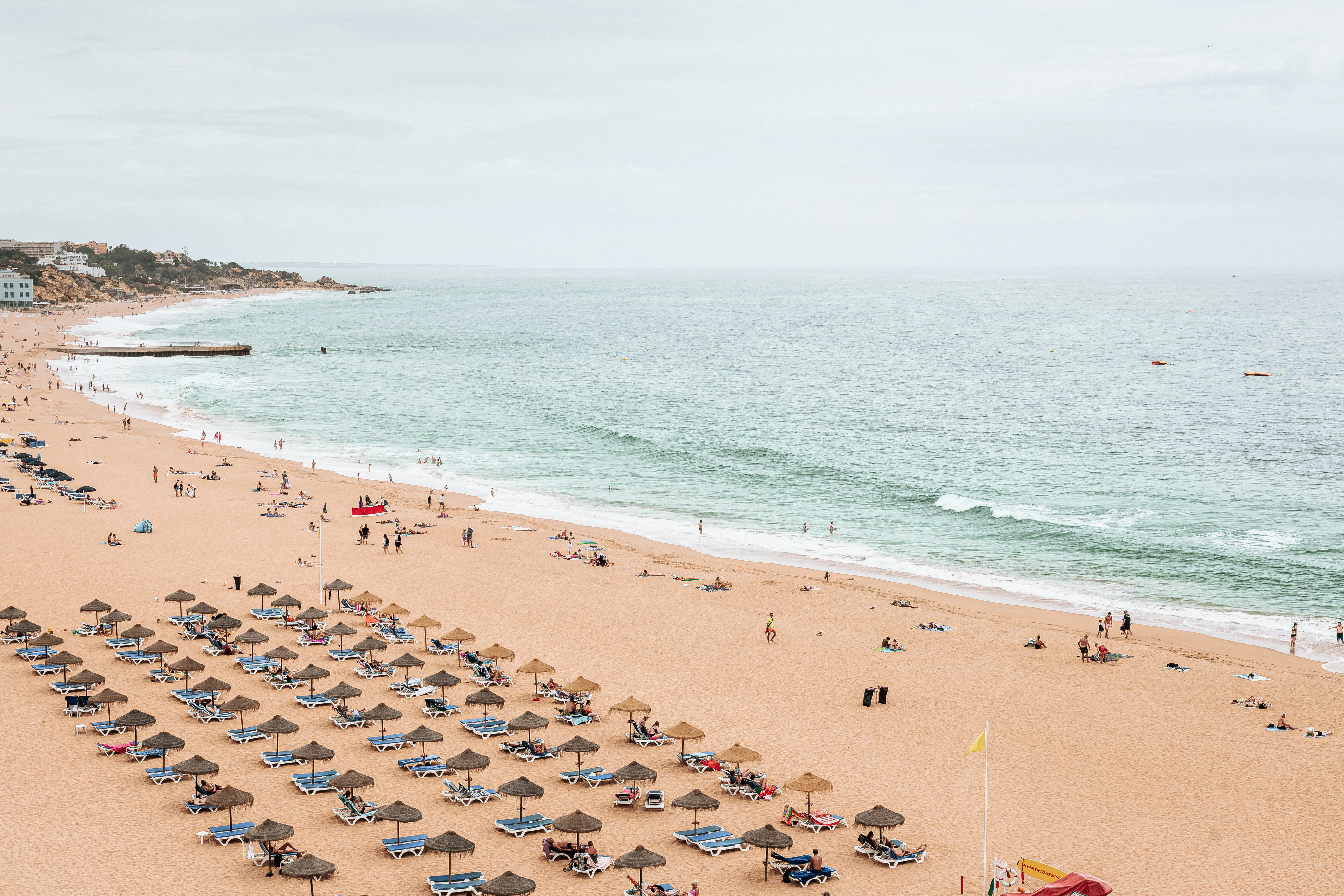 a beach with people and umbrellas