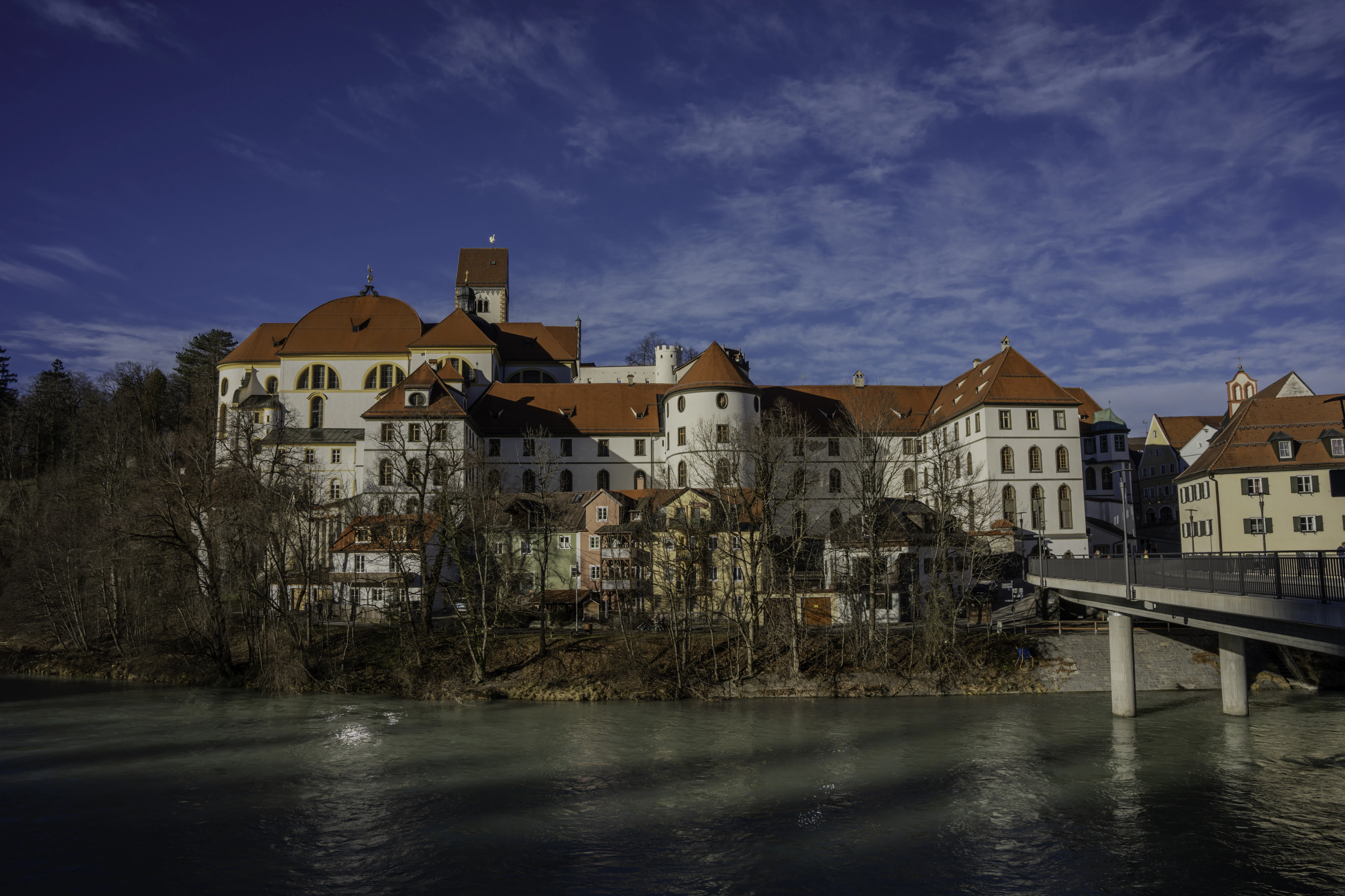 a bridge crossing over a river in front of a large building