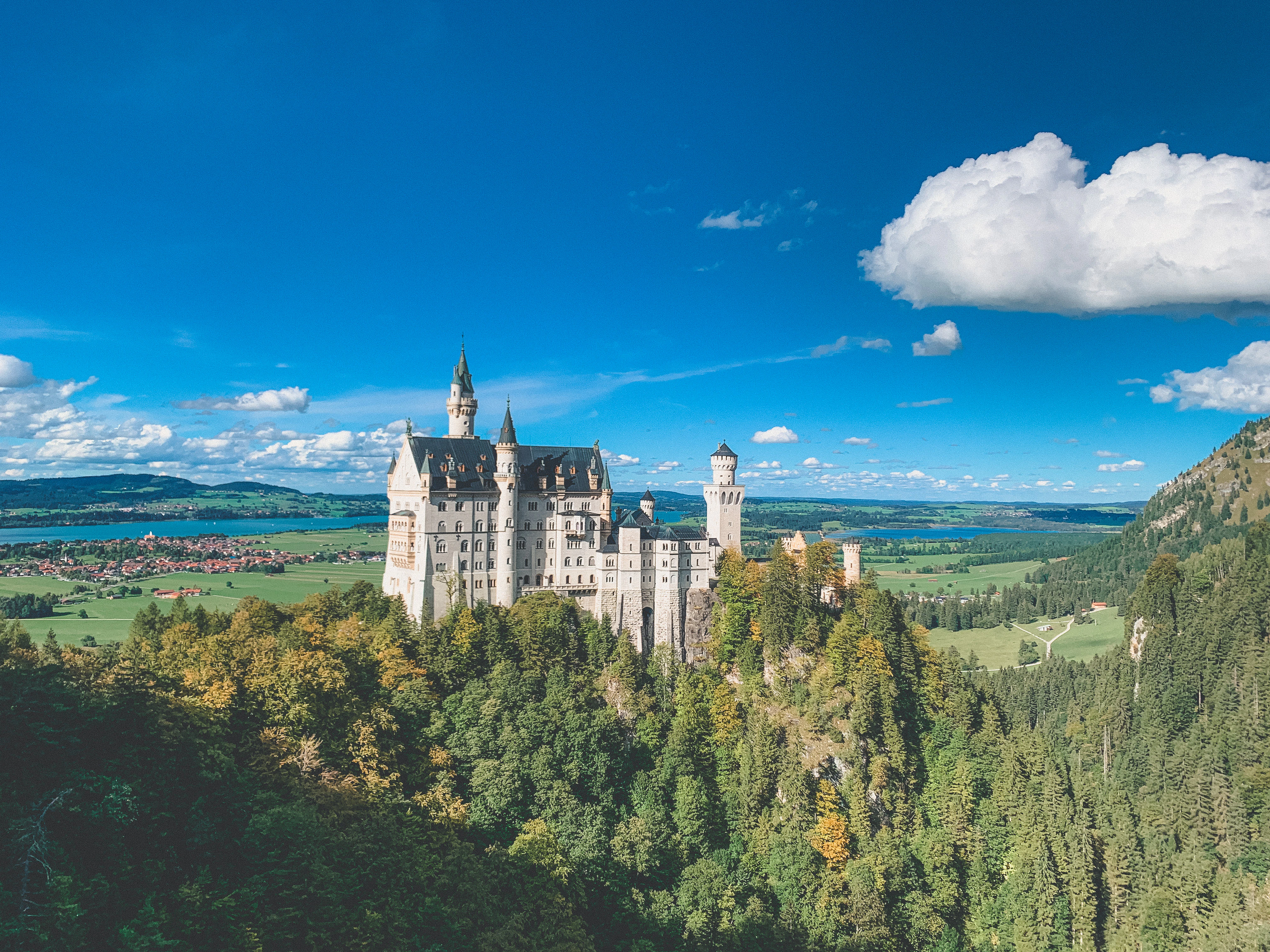 white and gray castle on top of hill under blue sky during daytime