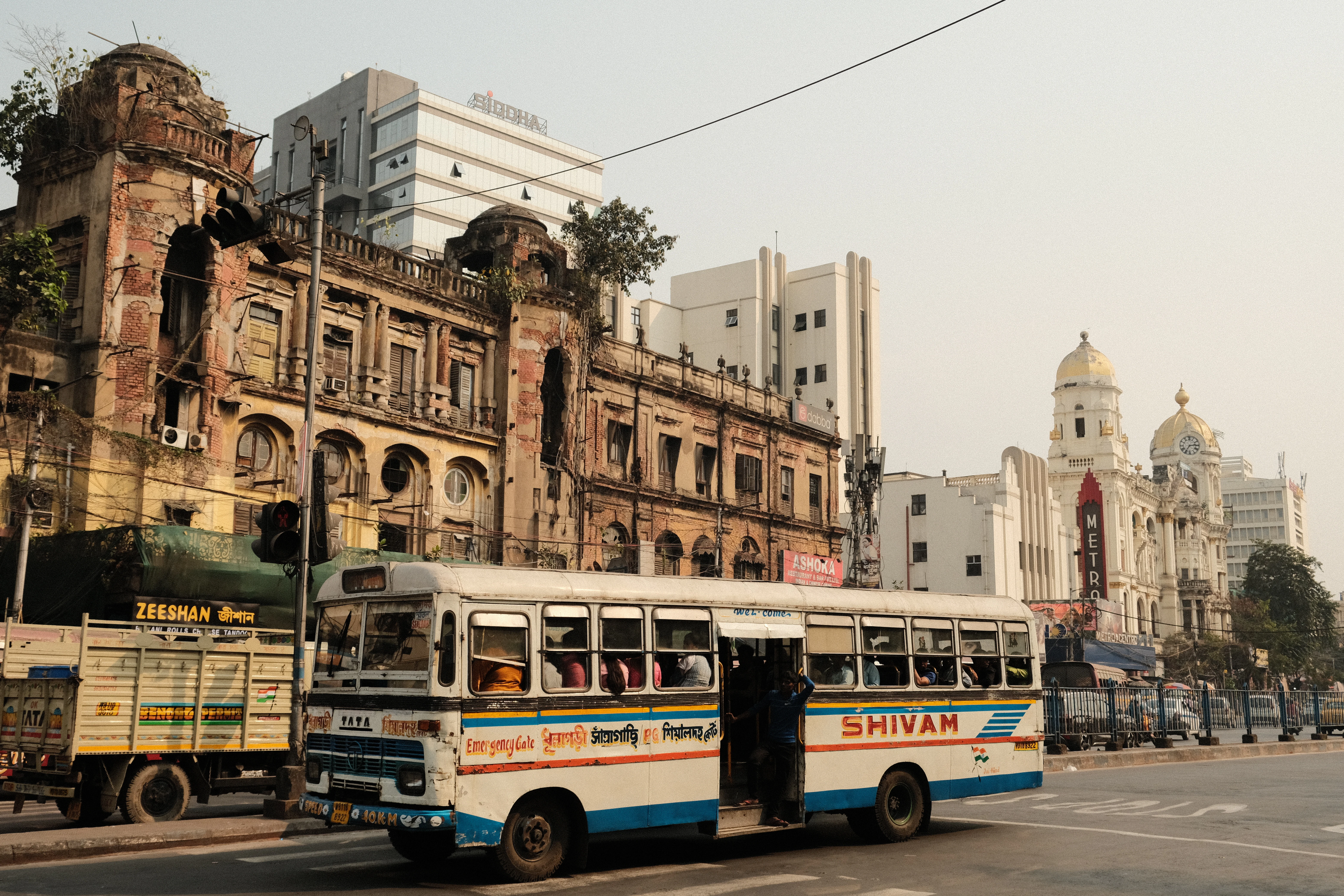 a bus driving down a street next to tall buildings