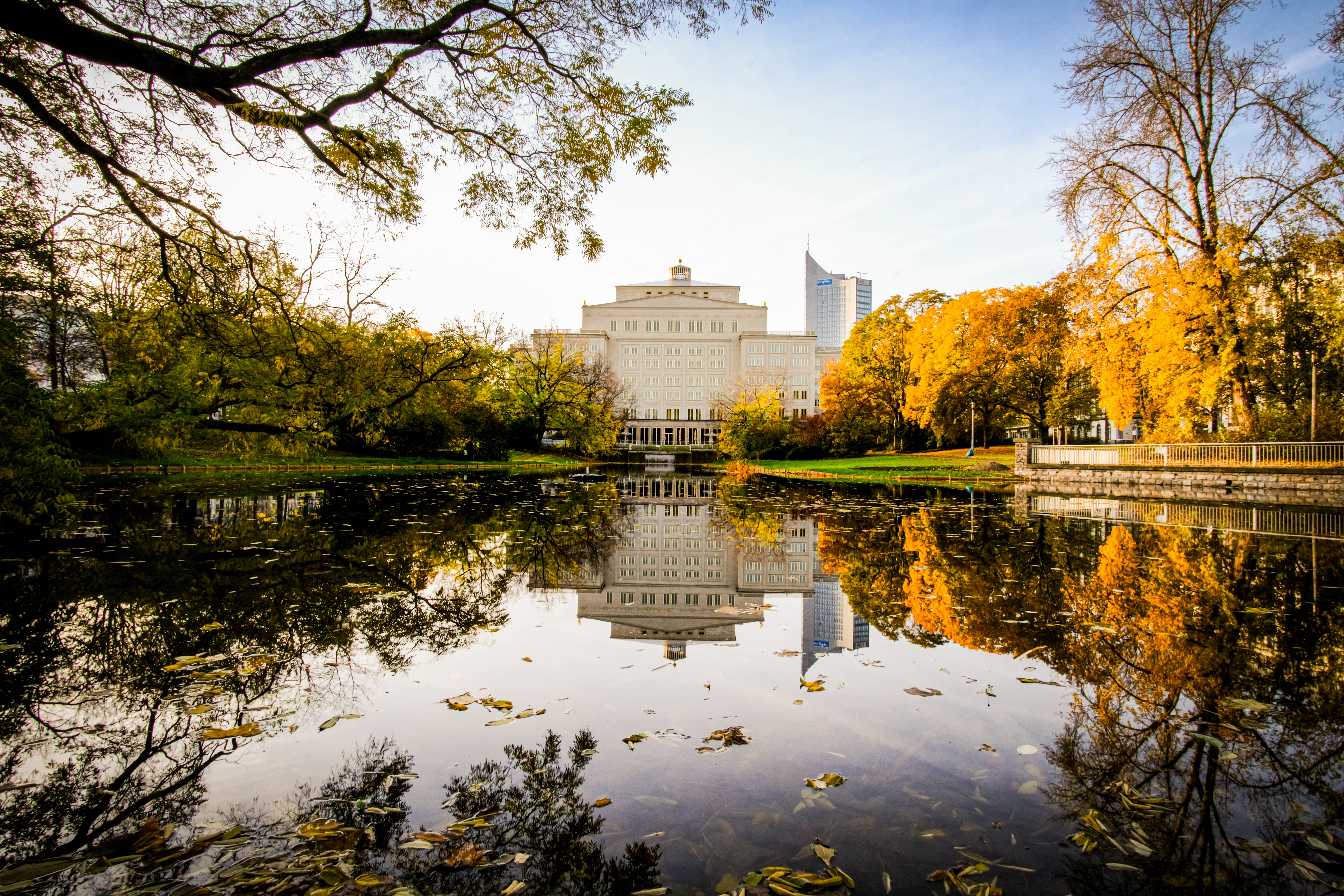 Building reflected in calm water with autumn trees