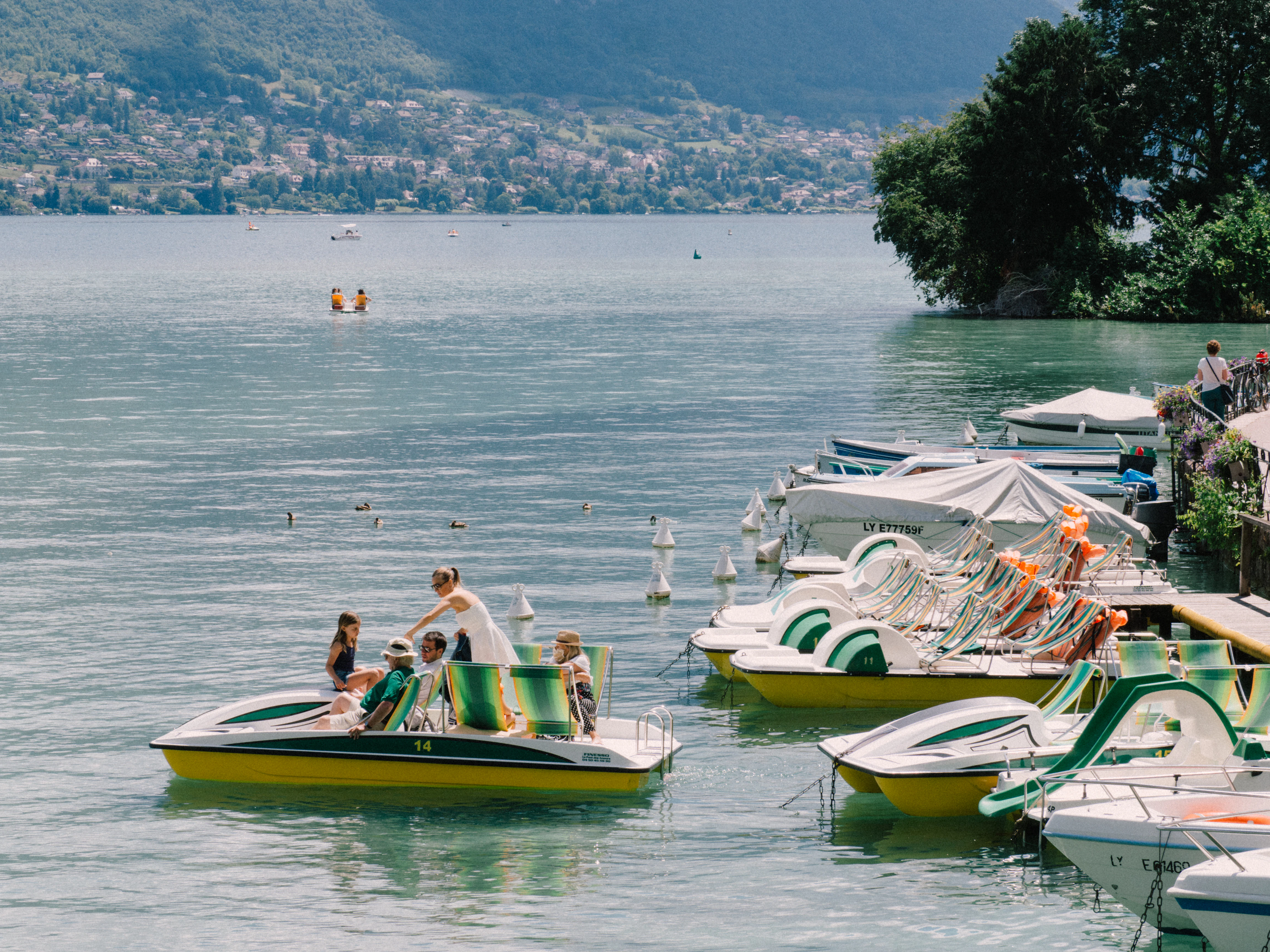 woman in white shirt sitting on yellow and green kayak on sea during daytime