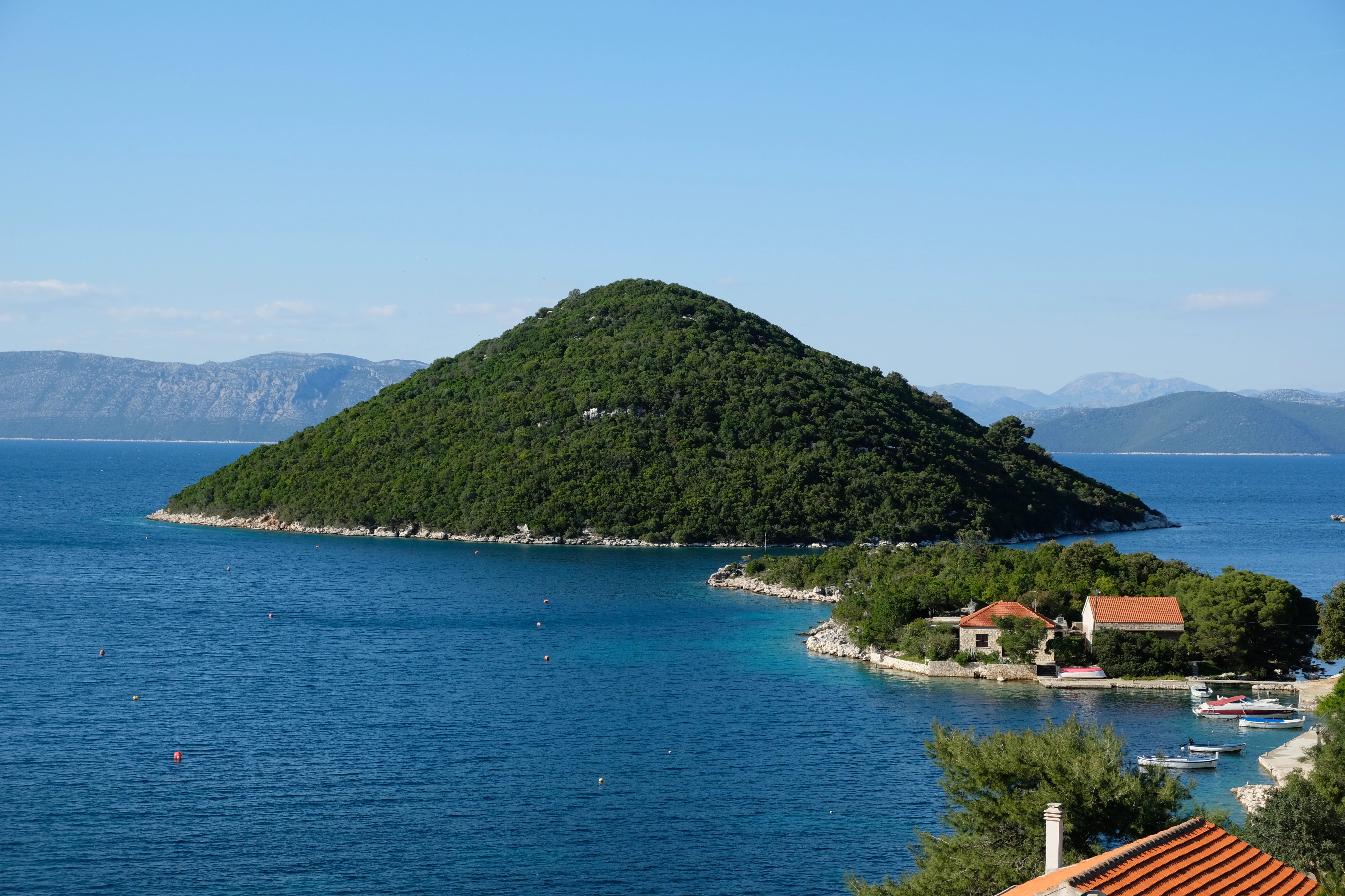 a body of water with a hill in the background