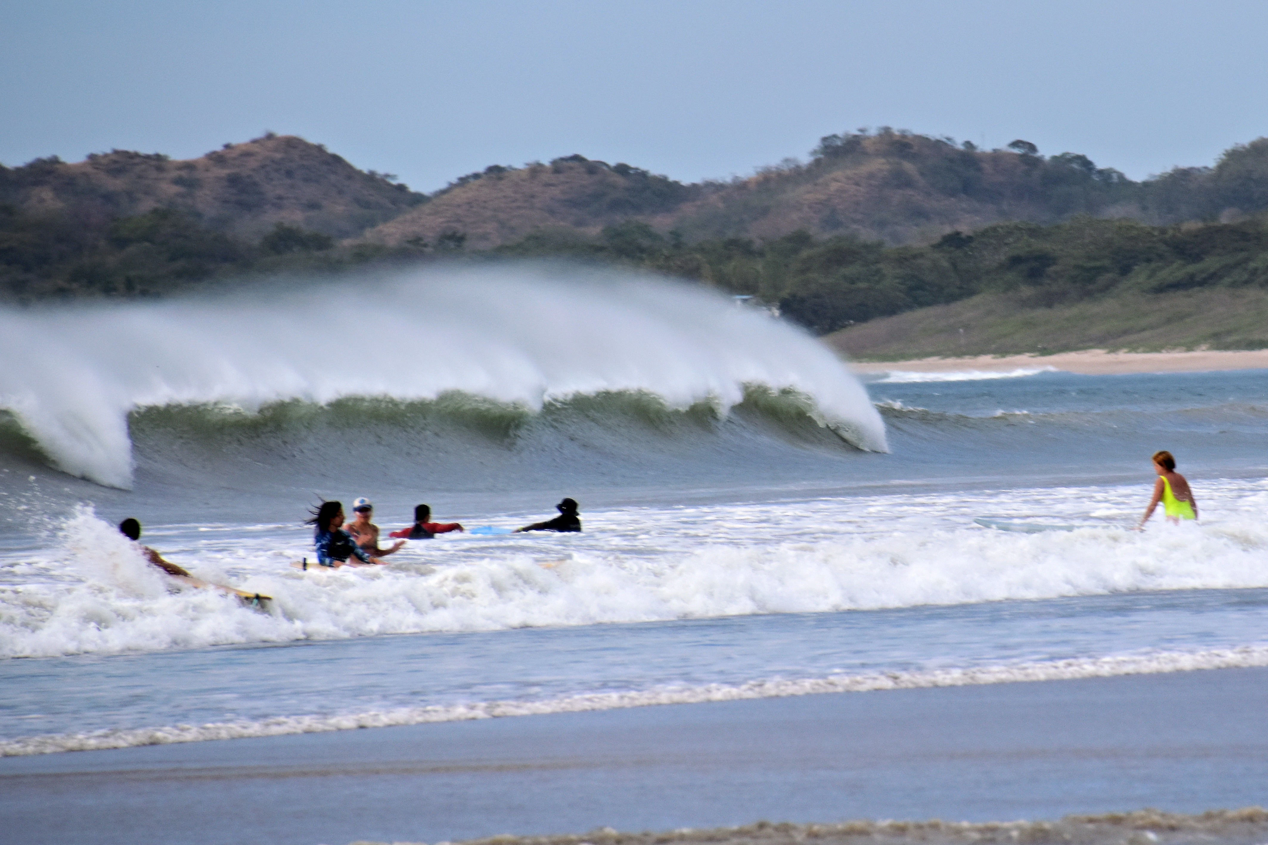 a group of people riding surfboards on top of a wave
