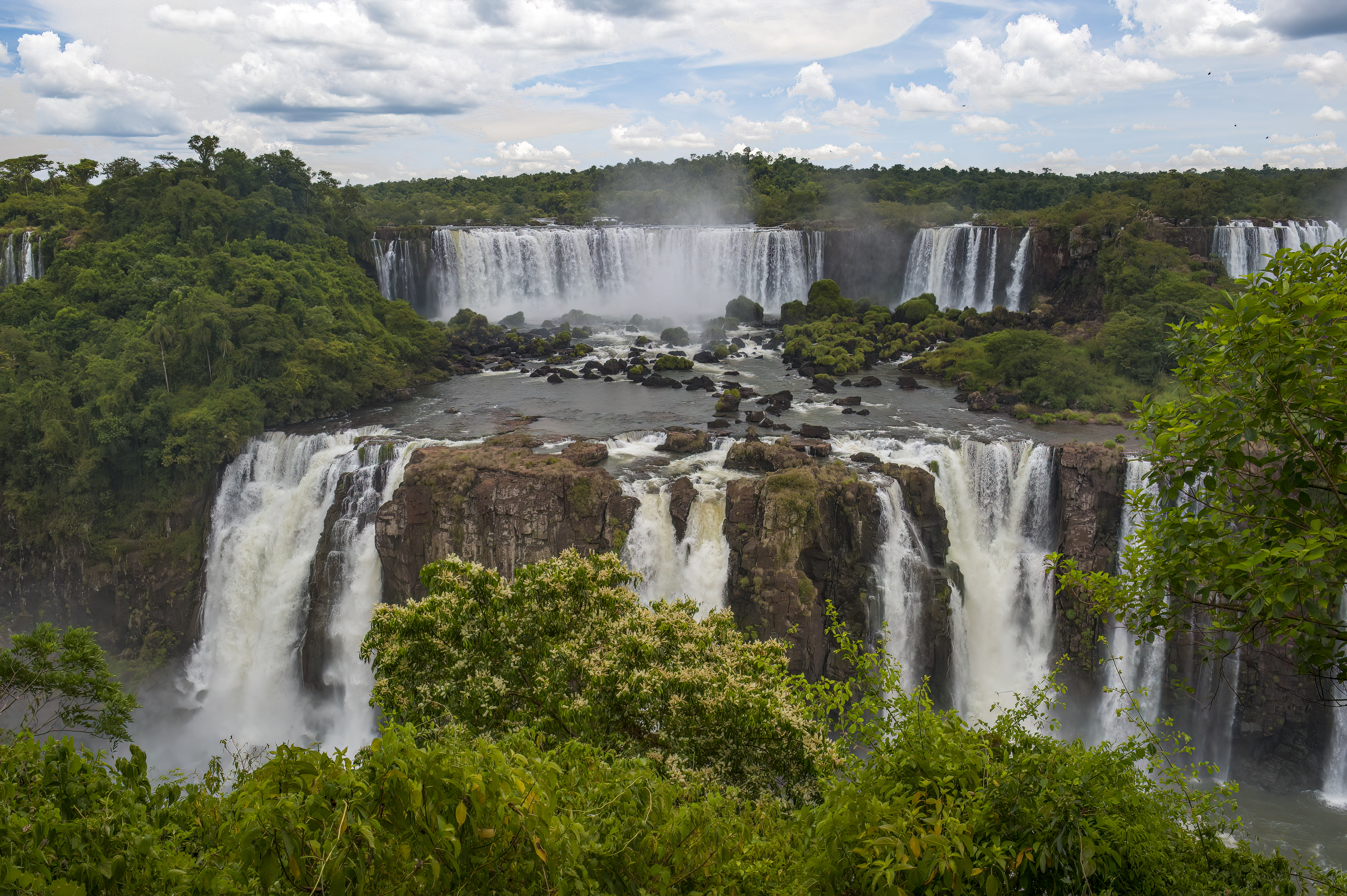 a large waterfall surrounded by lush green trees