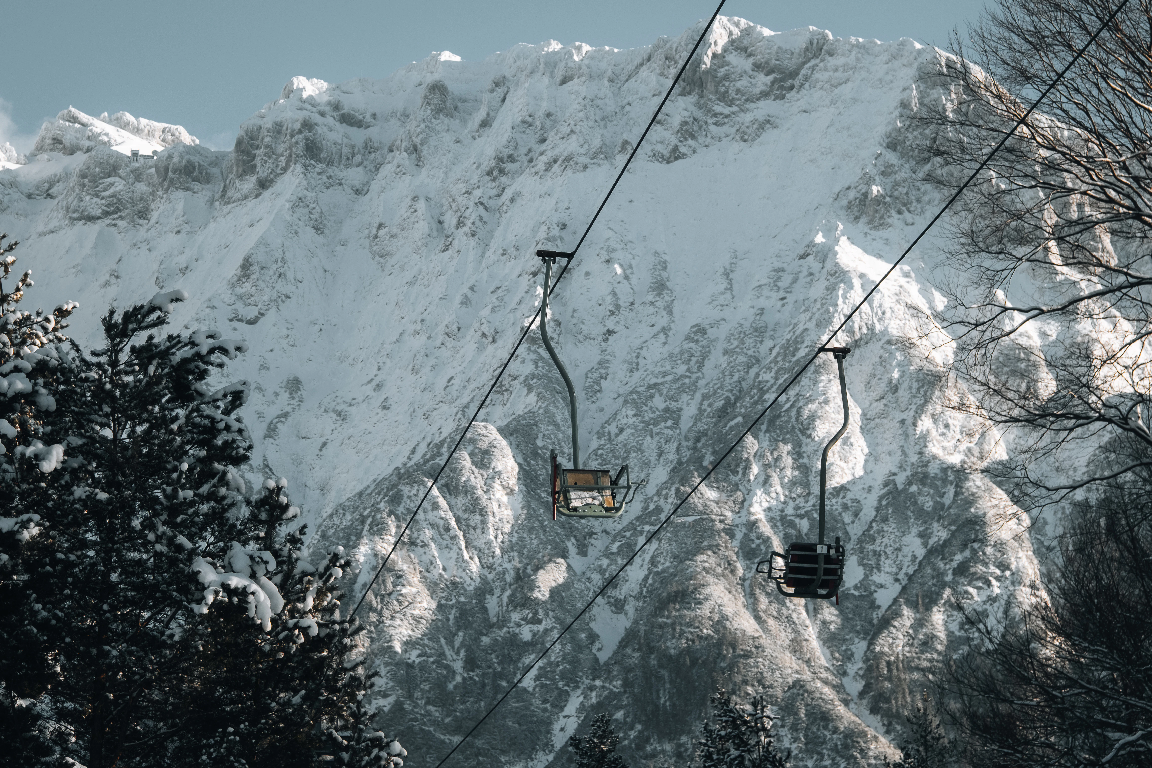 Ski lift ascending snow-covered mountains with trees