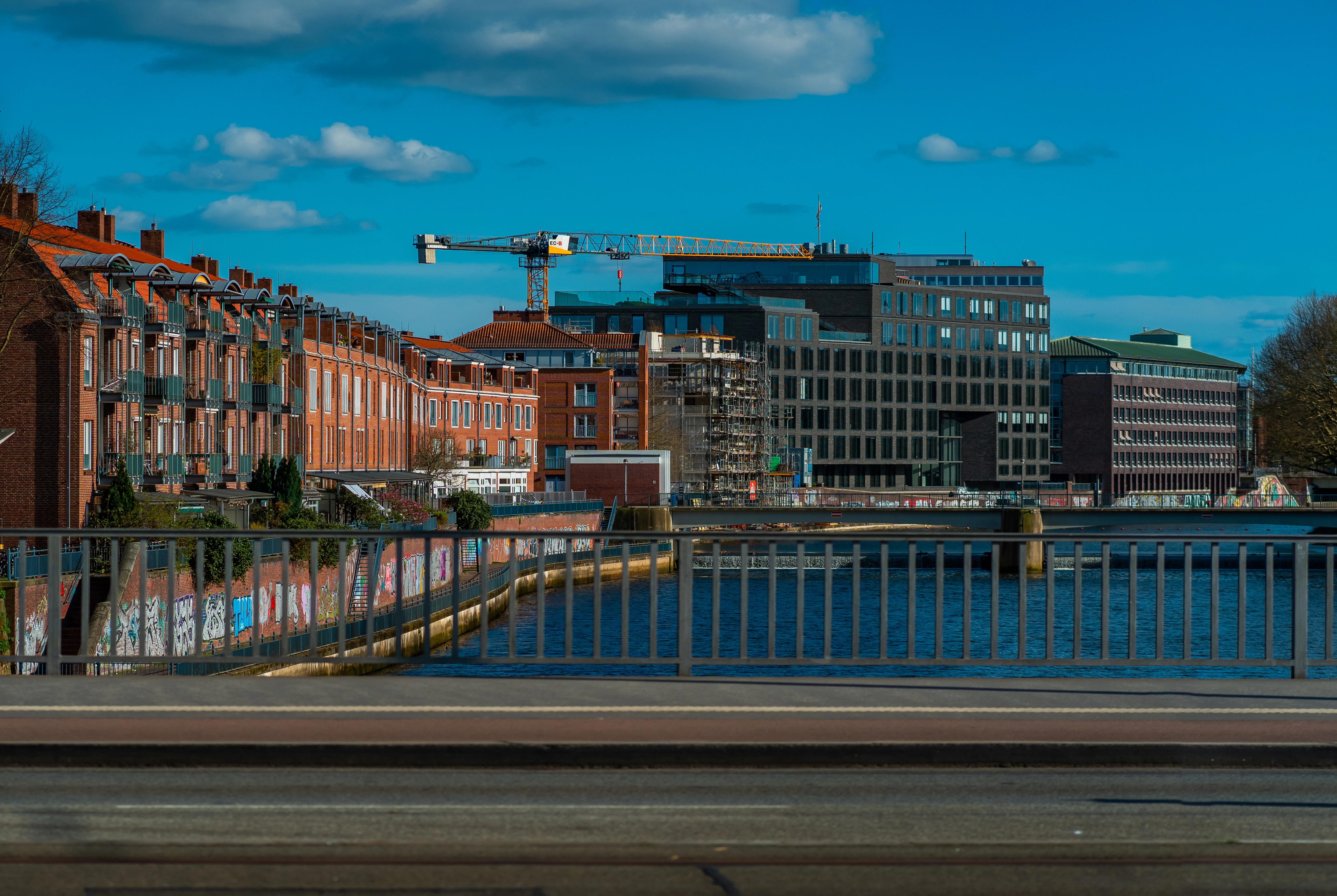 Buildings and a bridge span the river.